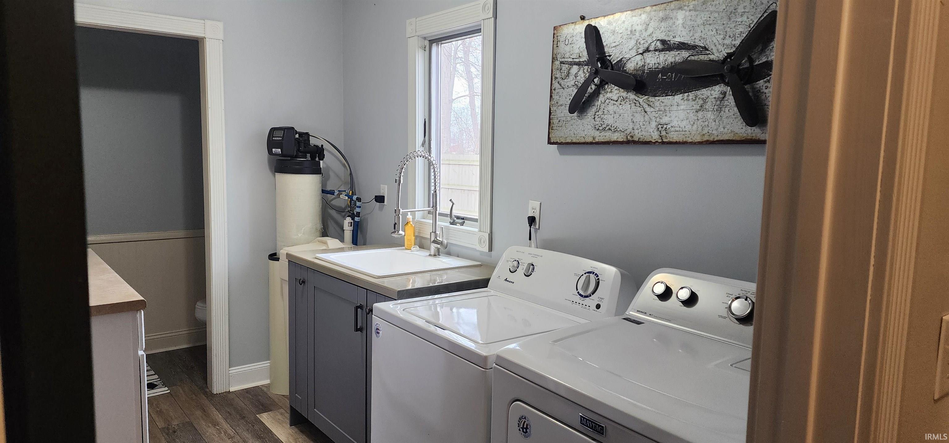 Laundry room with dark wood finished floors and washer and dryer