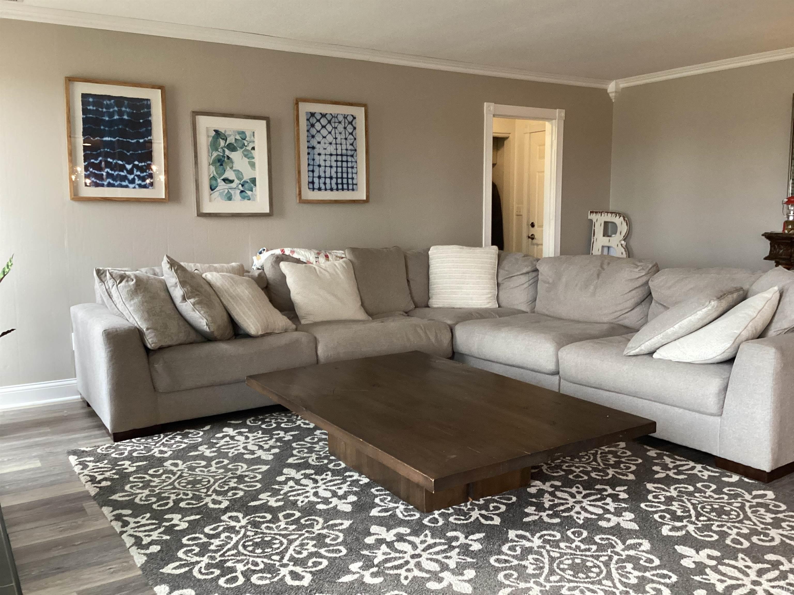 Living room featuring ornamental molding and wood finished floors