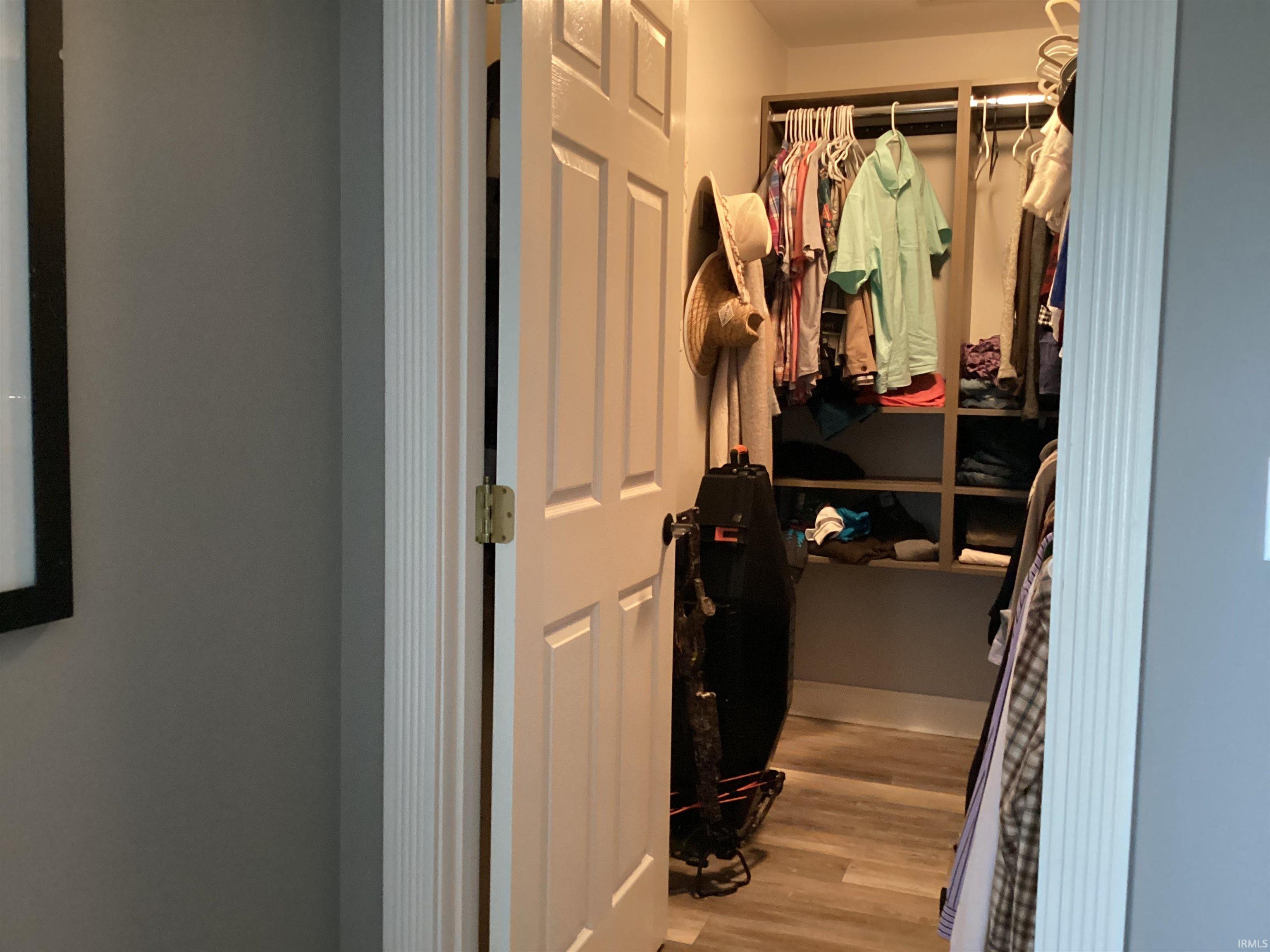 Walk in closet with light wood-type flooring