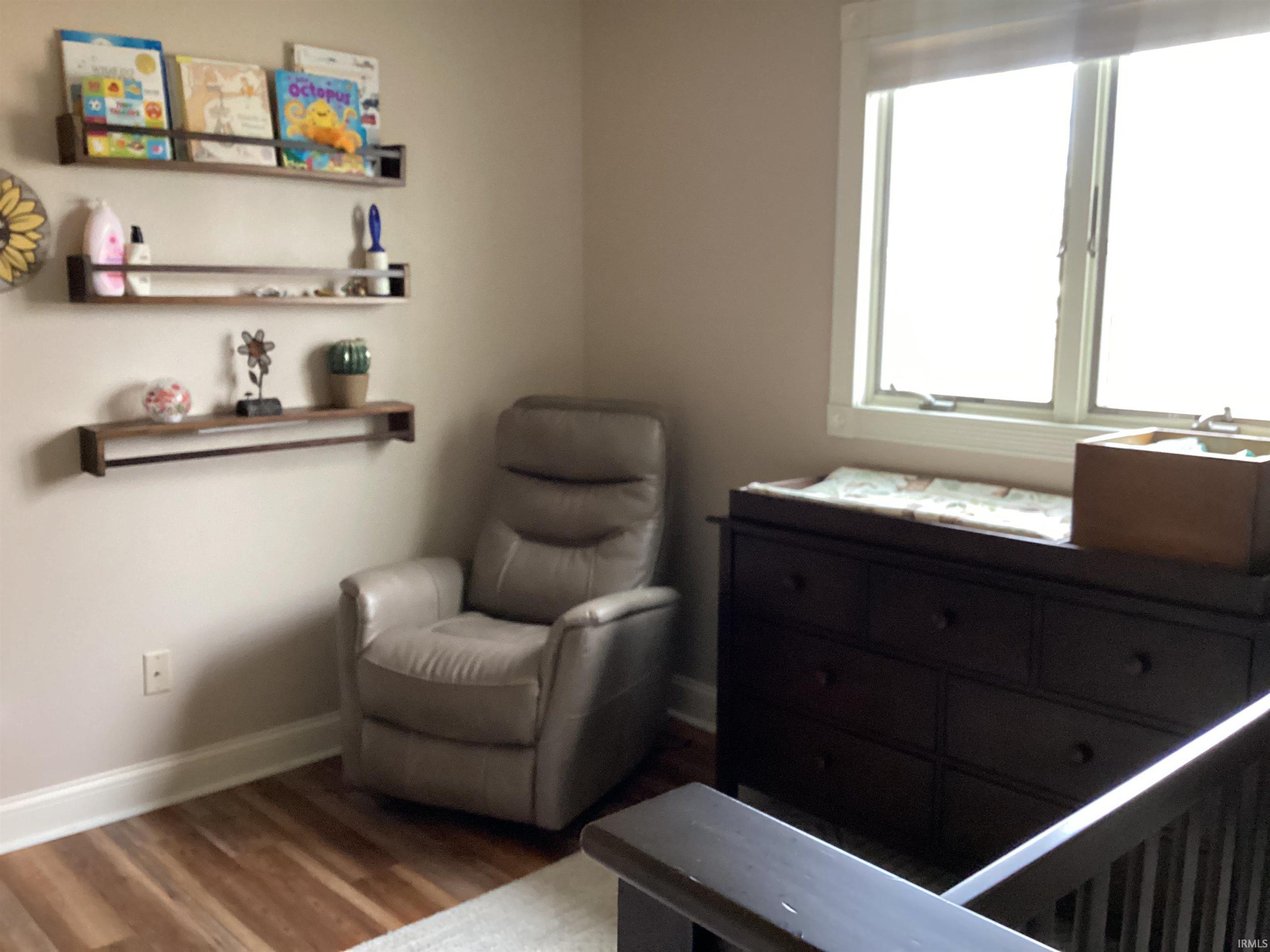 Sitting room featuring baseboards and dark wood-style flooring