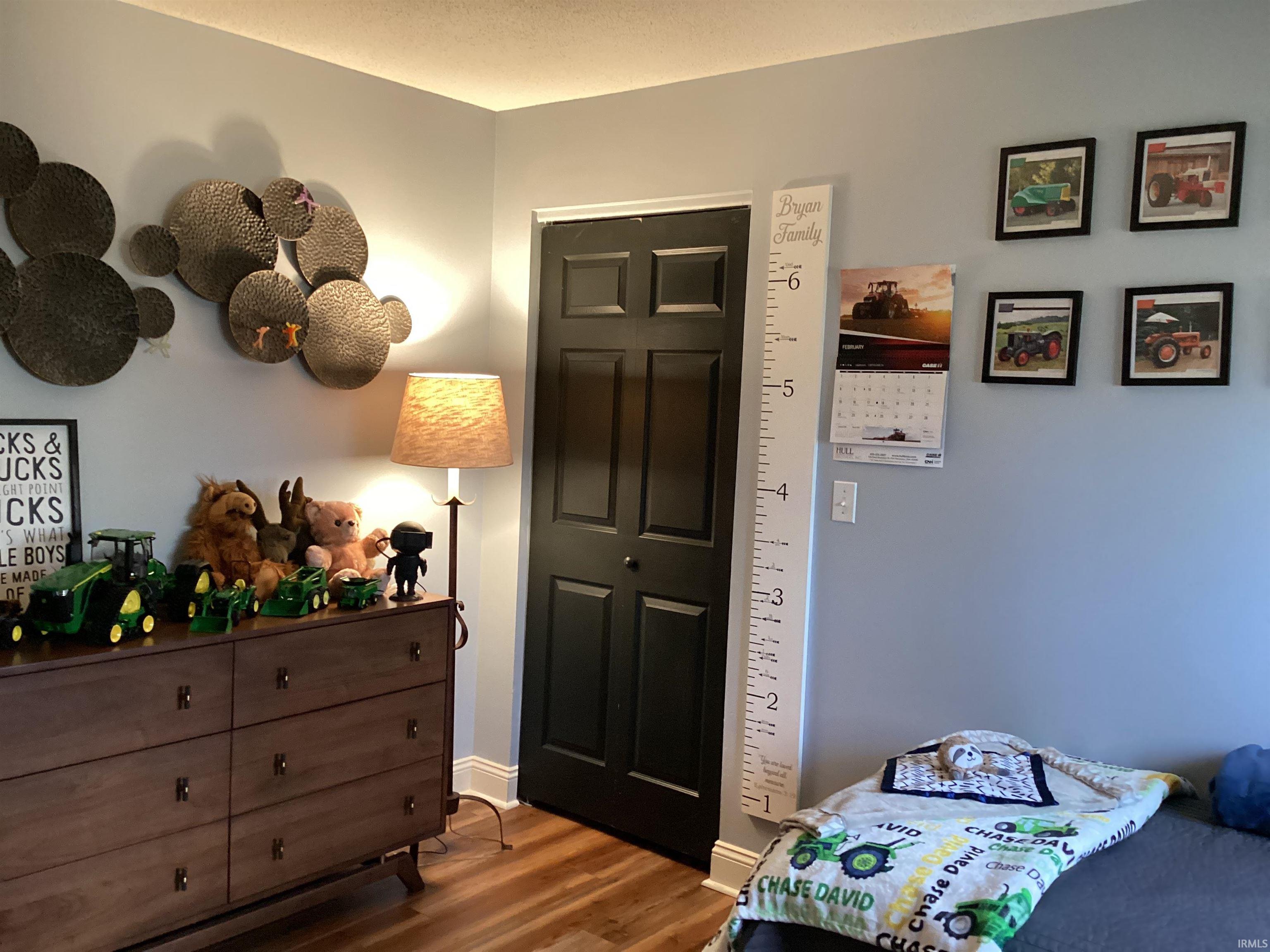 Bedroom featuring wood finished floors and baseboards