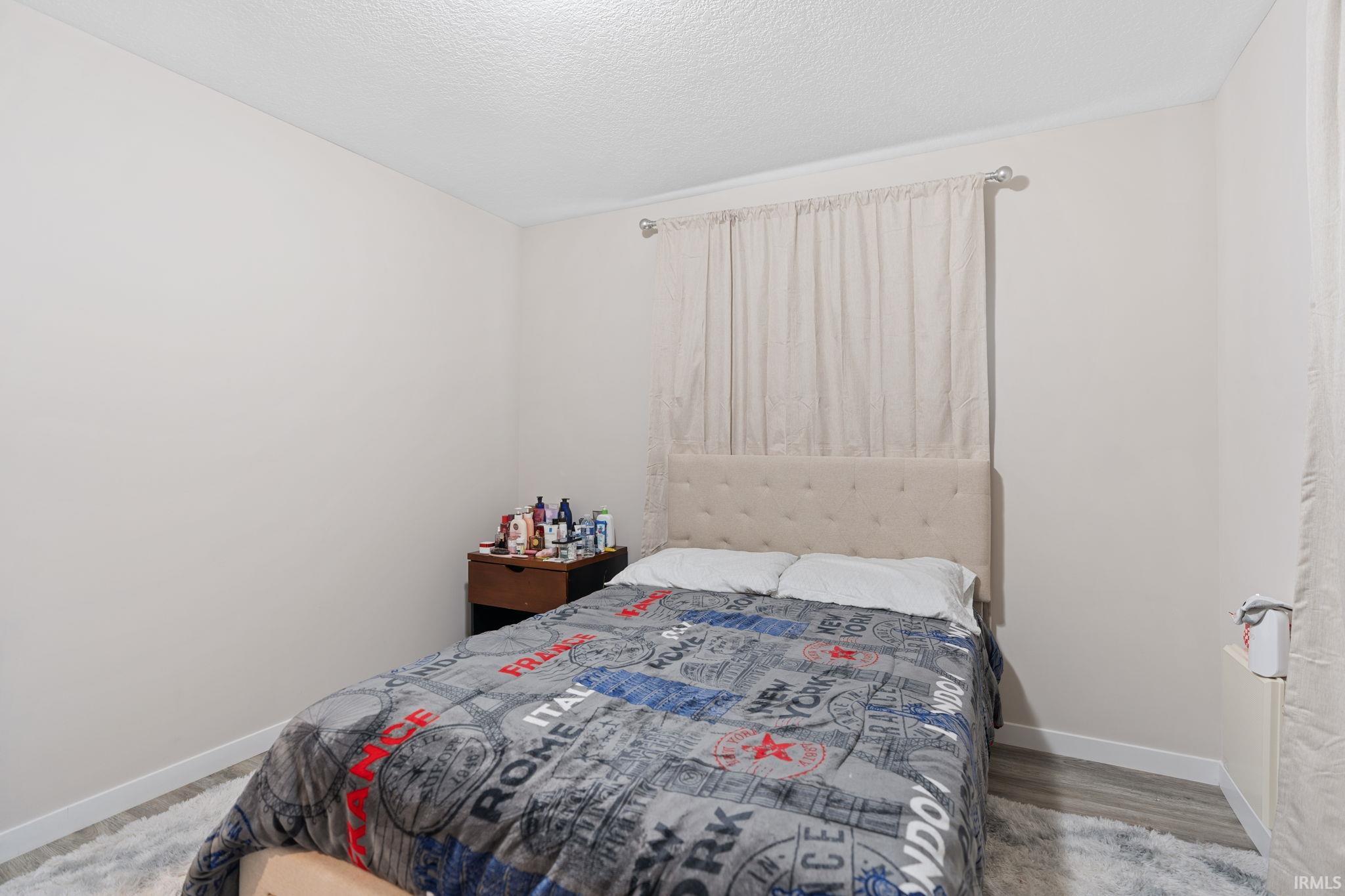 Bedroom featuring a textured ceiling and light wood-style flooring