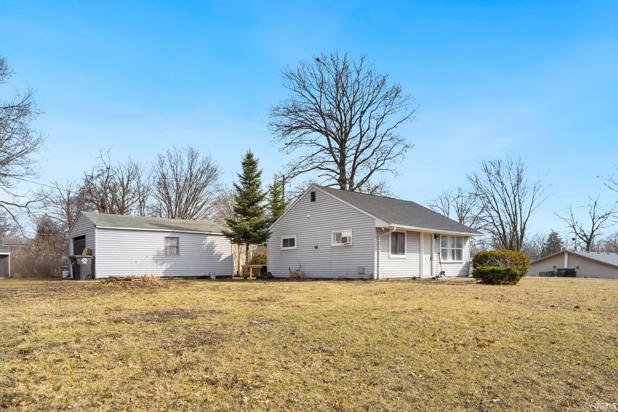 Back of property with a lawn