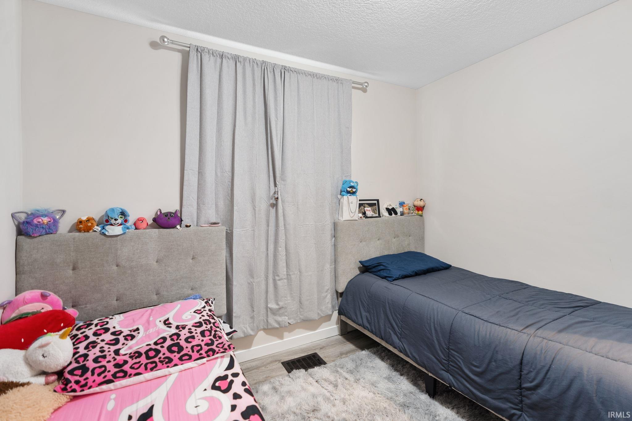 Bedroom featuring a textured ceiling and light wood finished floors