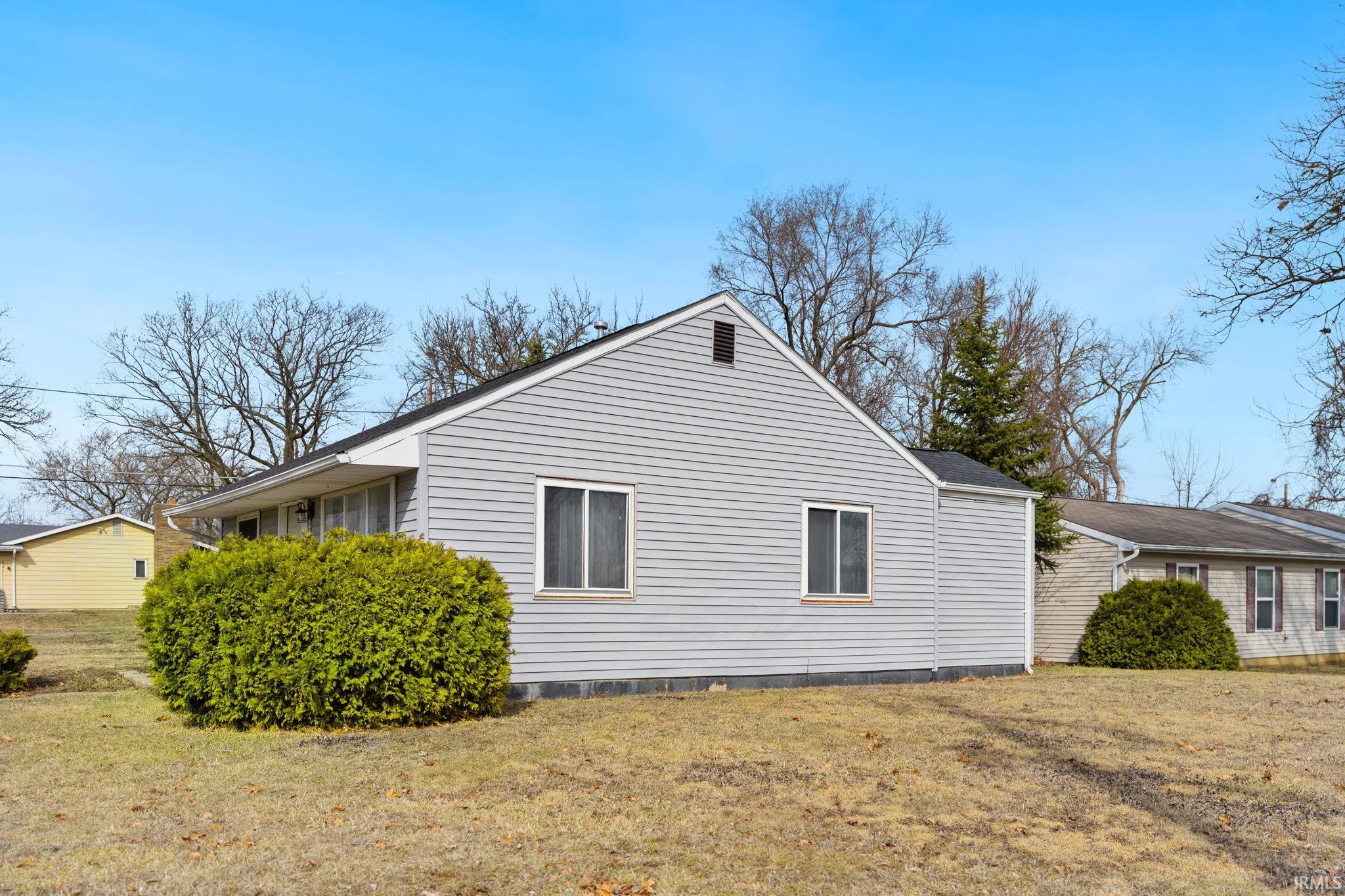 View of property exterior with a yard
