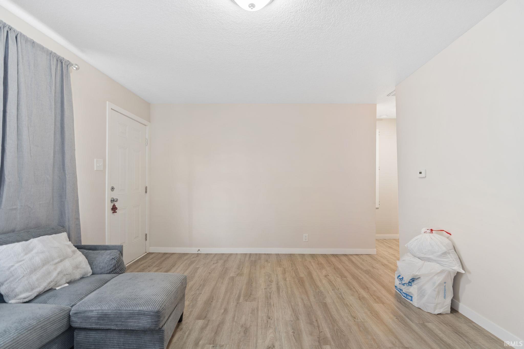 Sitting room with light wood-style flooring and a textured ceiling