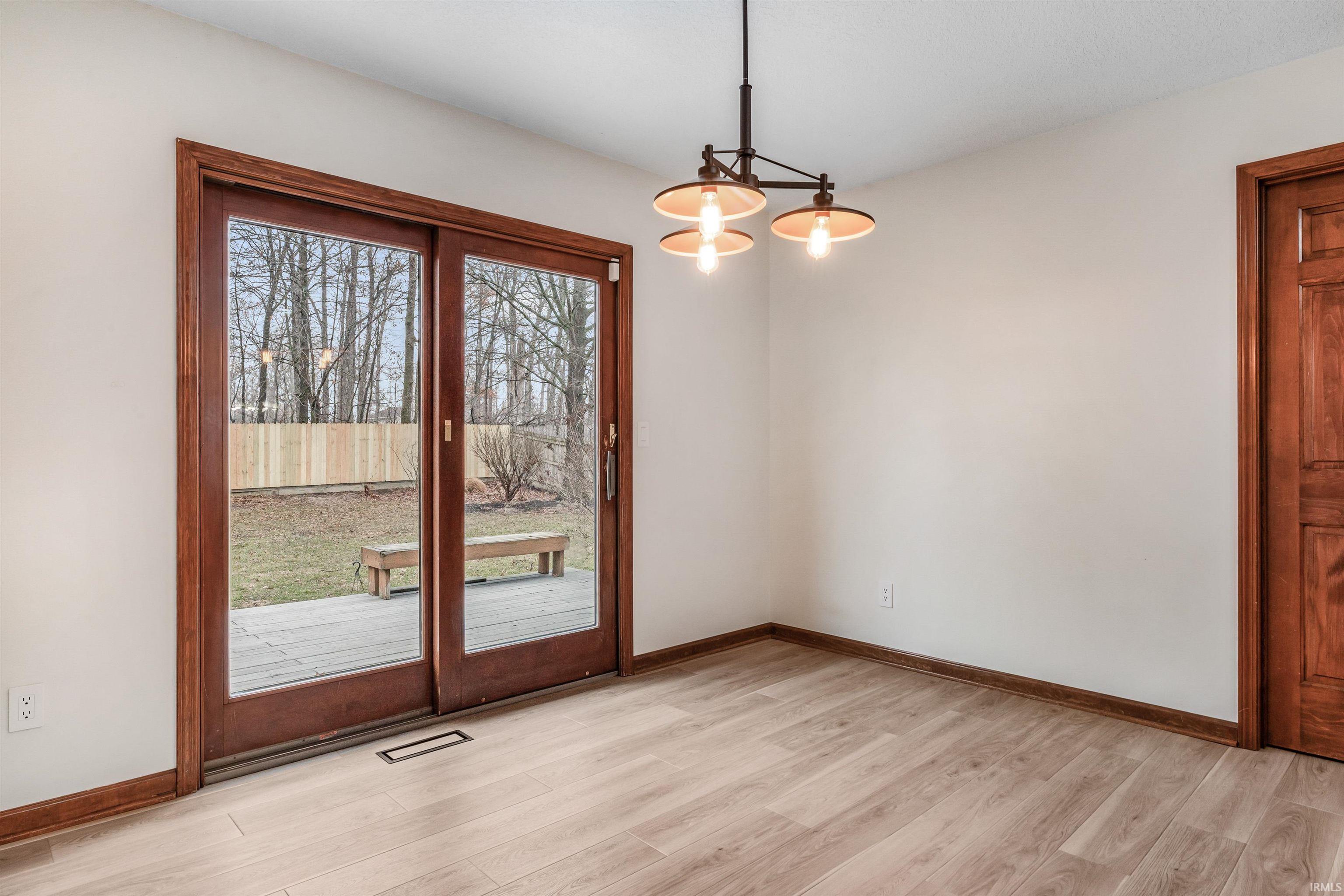 Doorway to outside featuring wood finished floors and hanging lights
