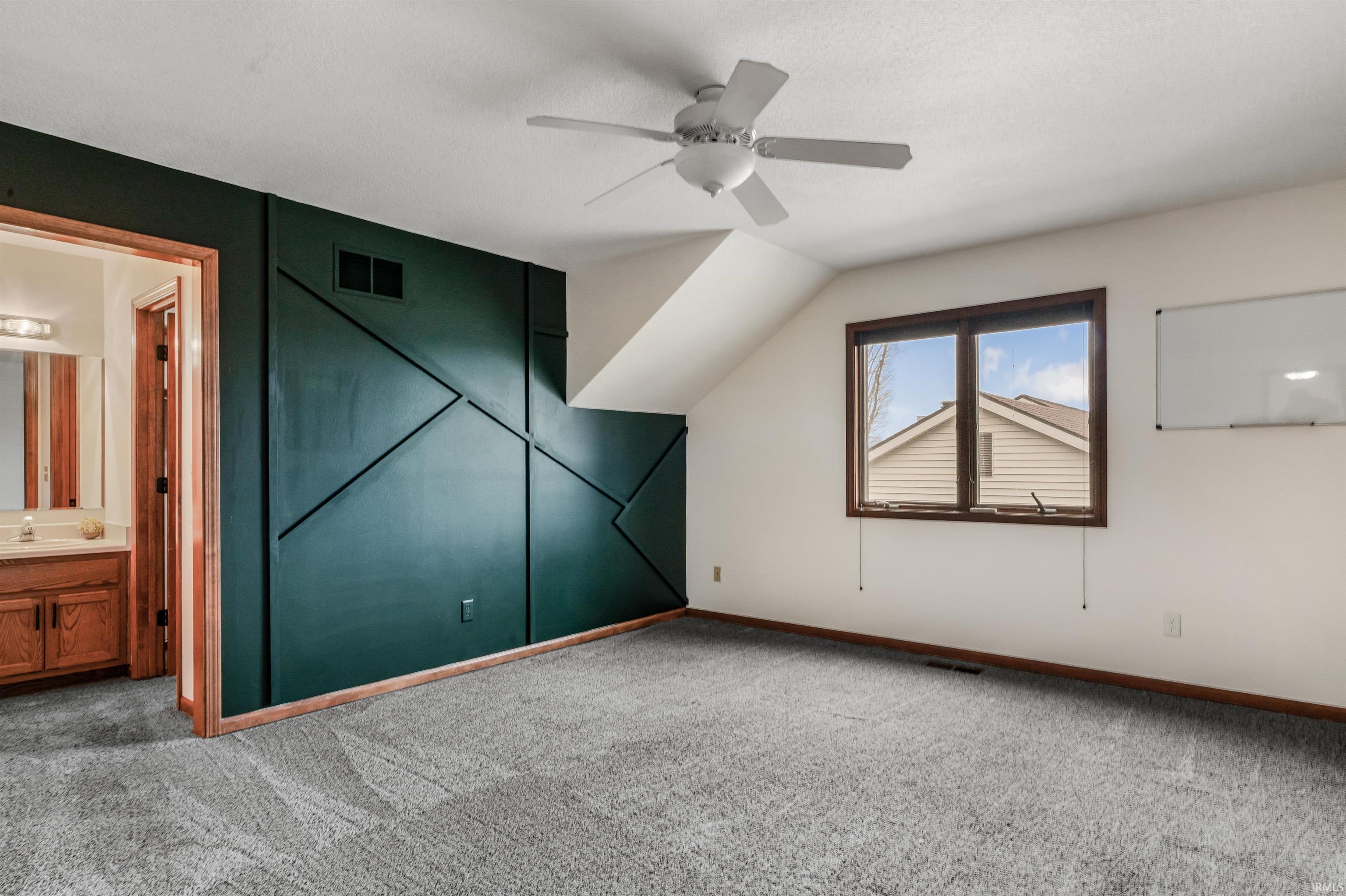 Additional living space with carpet floors, a ceiling fan, and lofted ceiling