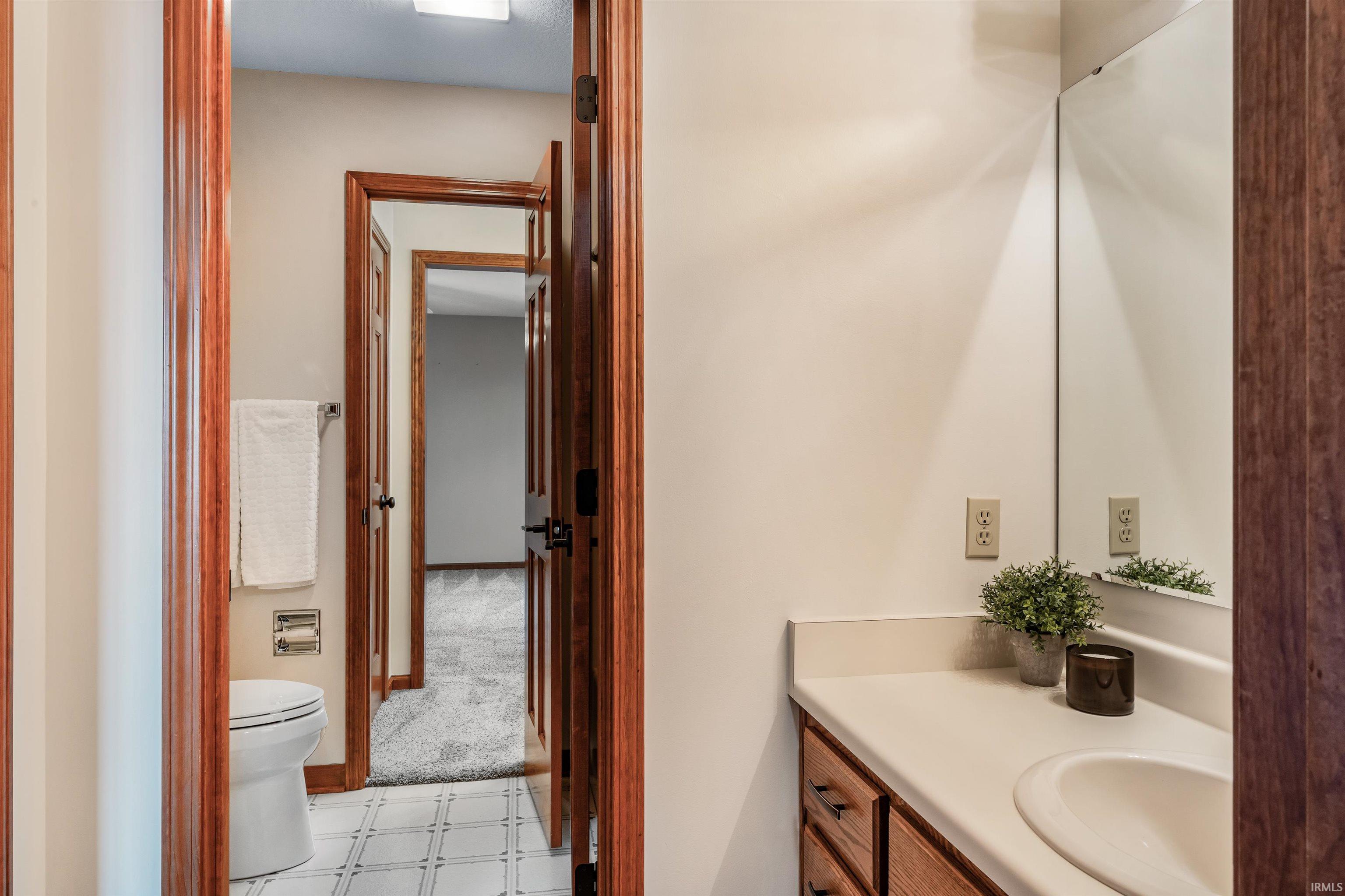 Half bathroom featuring vanity and light colored carpet