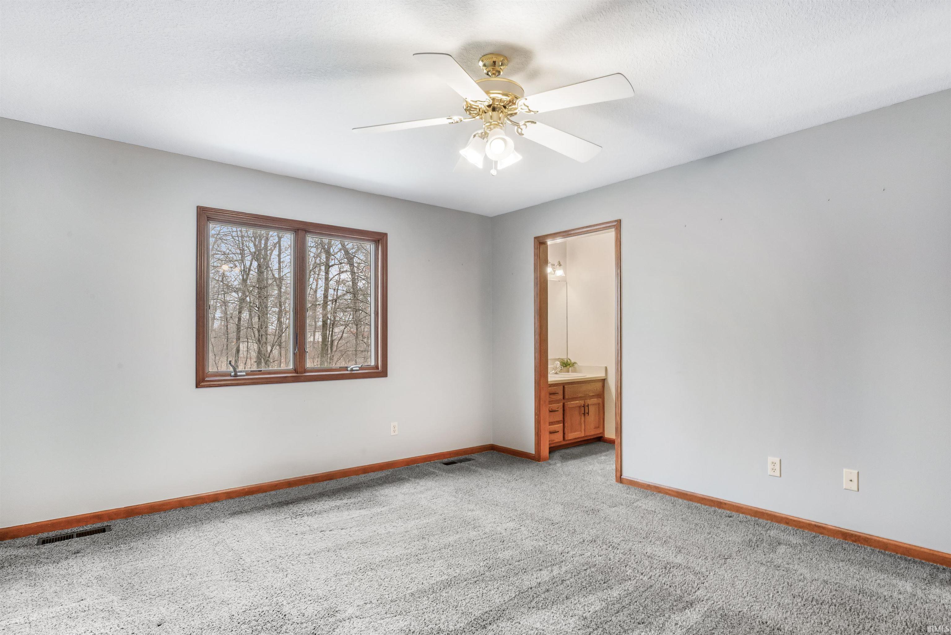 Unfurnished room featuring a ceiling fan and light colored carpet