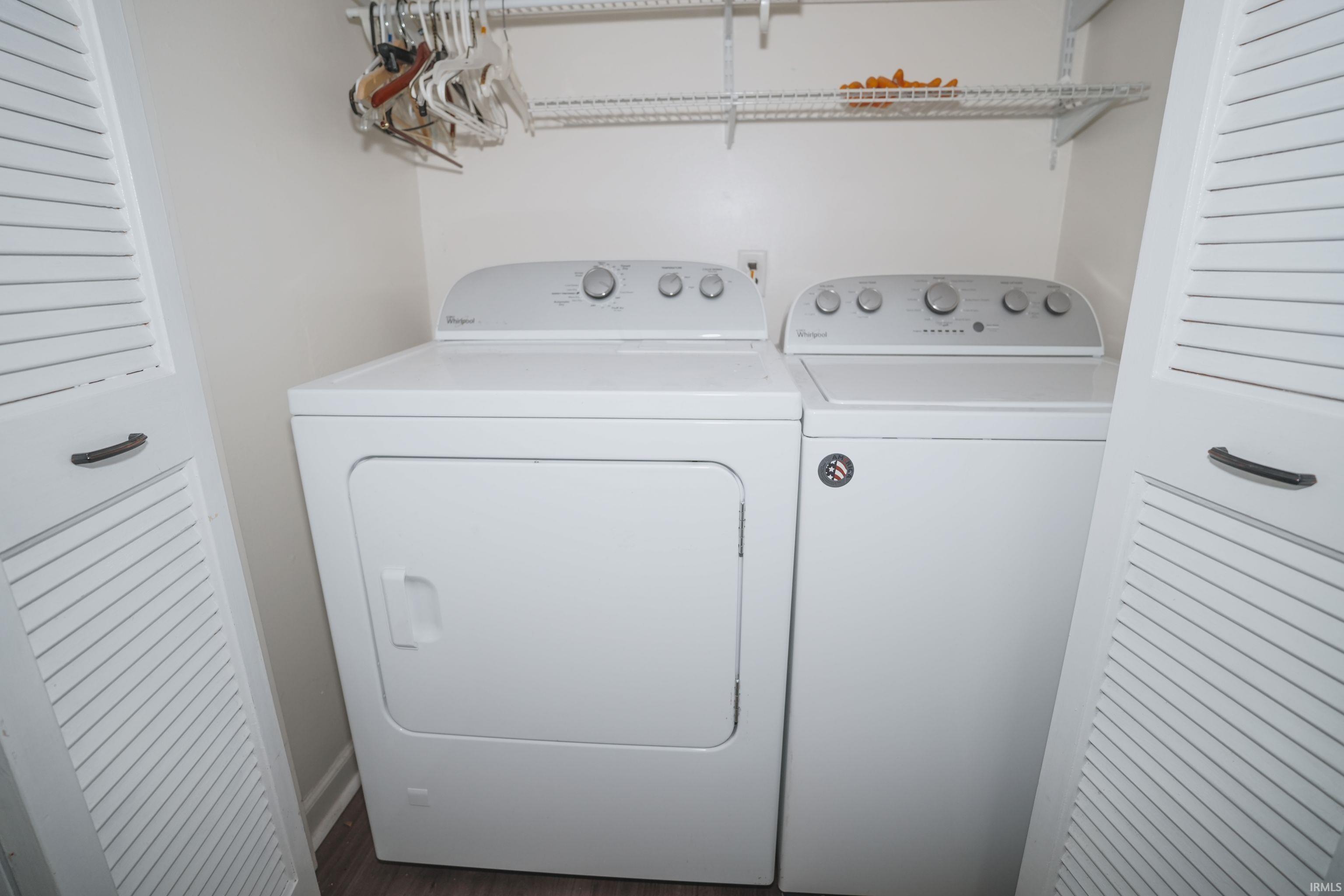 Laundry area featuring washing machine and clothes dryer and dark wood-style flooring