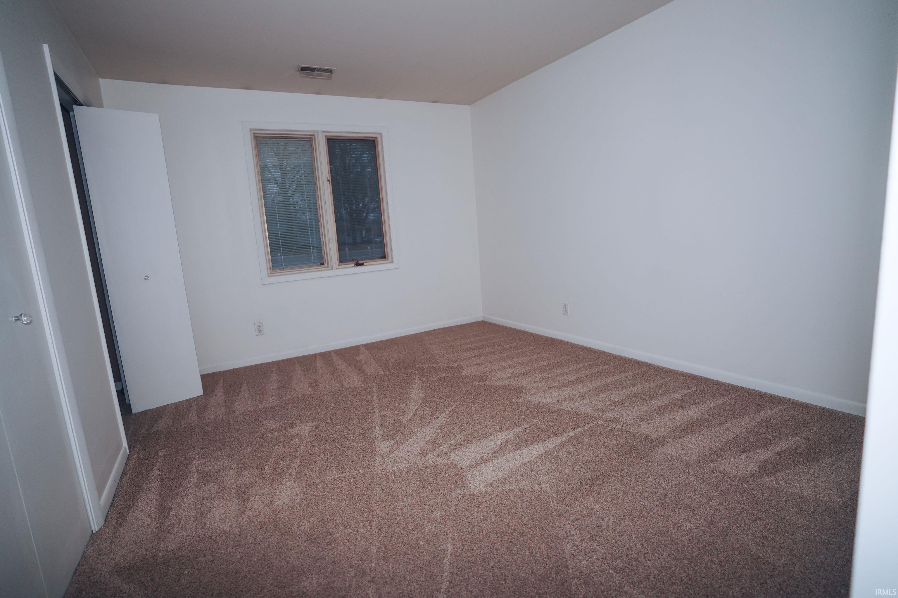 Unfurnished bedroom featuring carpet flooring and baseboards