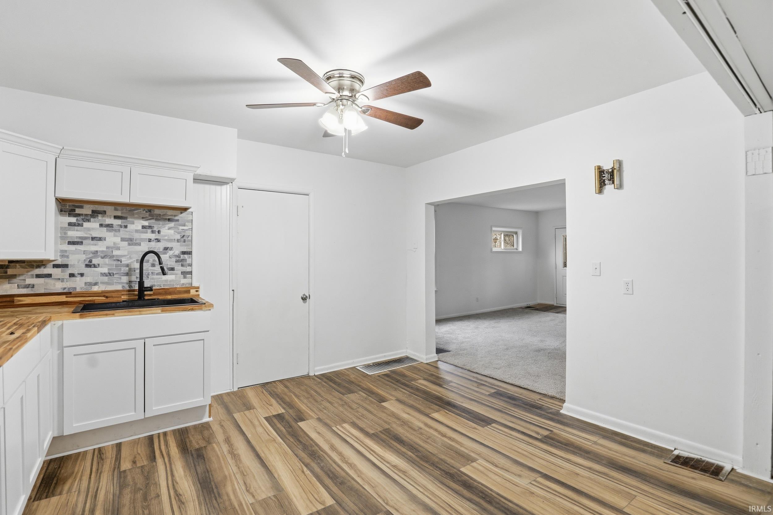 Unfurnished dining area featuring a ceiling fan and dark wood finished floors