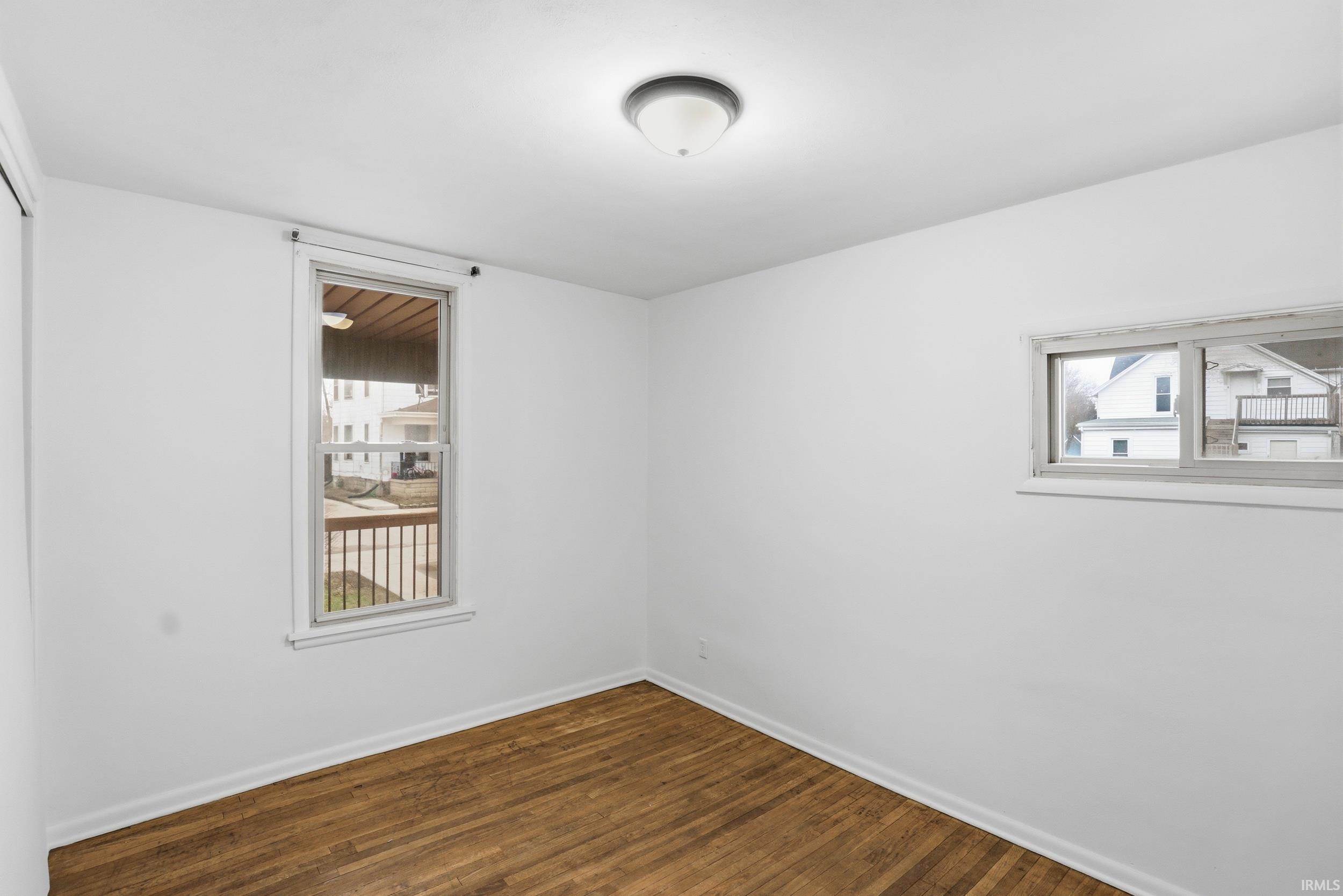 Empty room featuring dark wood-style floors and baseboards