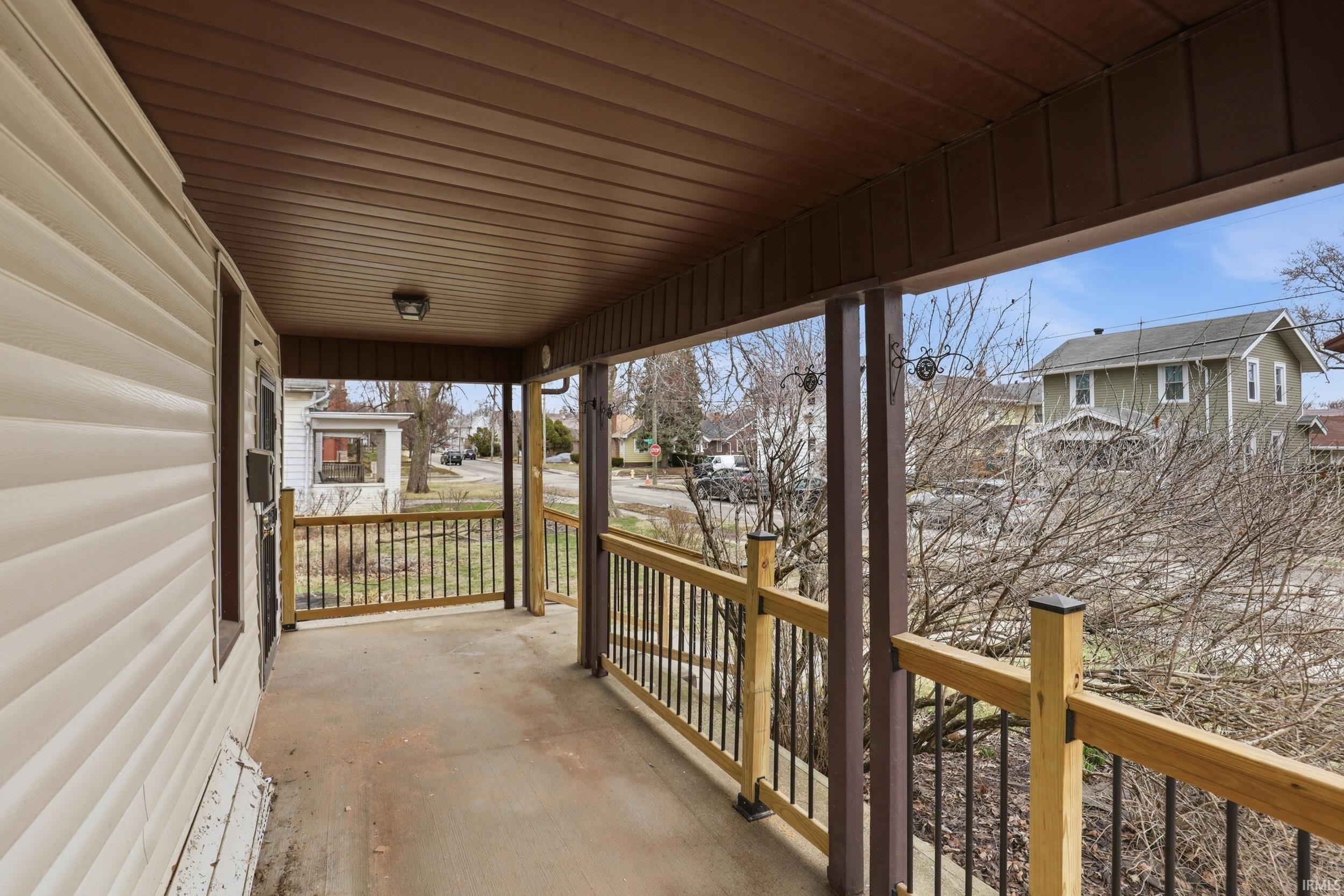 Covered porch featuring a residential view