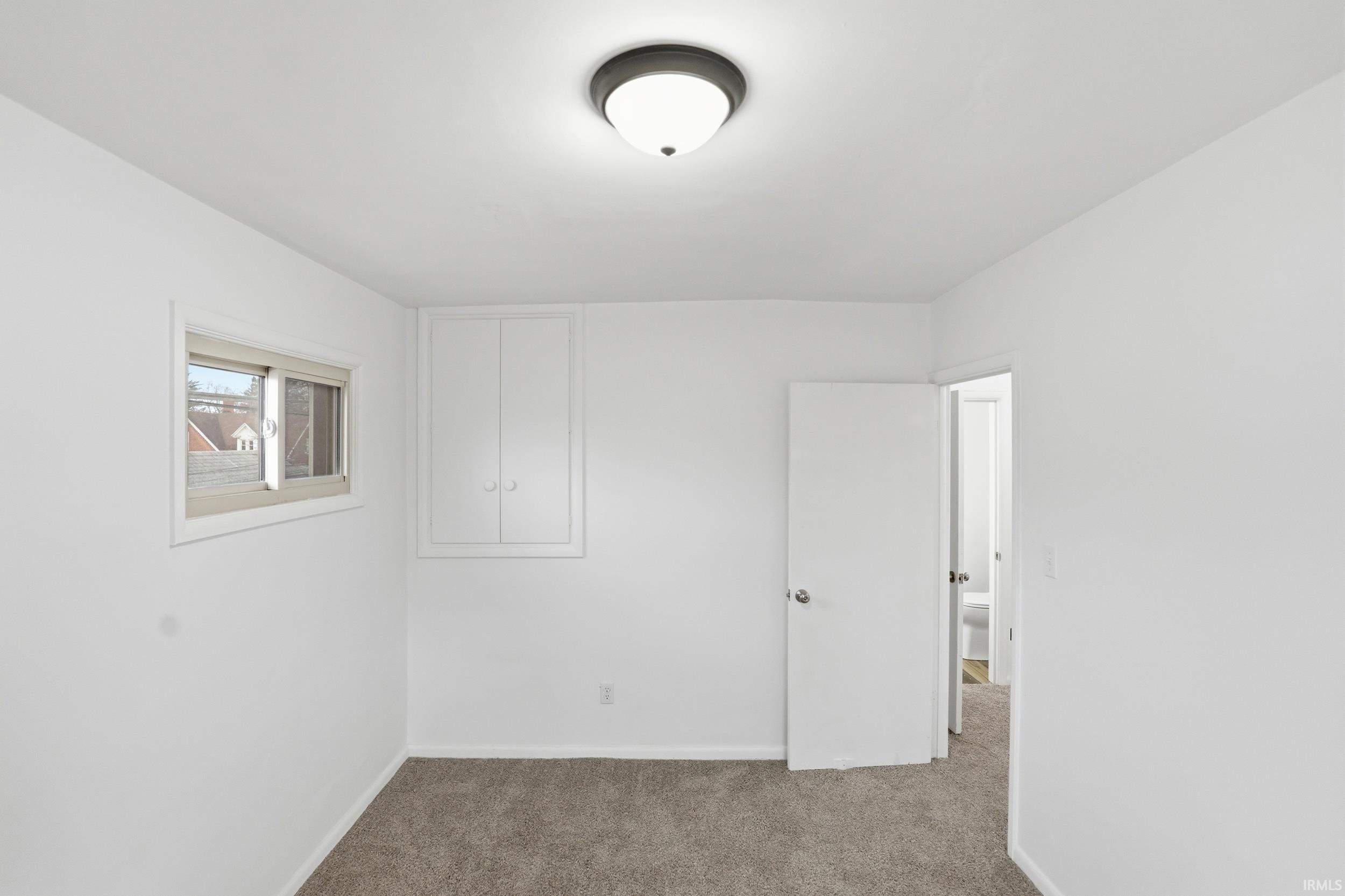 Spare room with baseboards and carpet