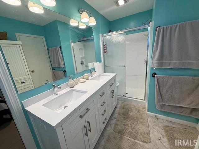 Bathroom featuring double vanity and a shower stall