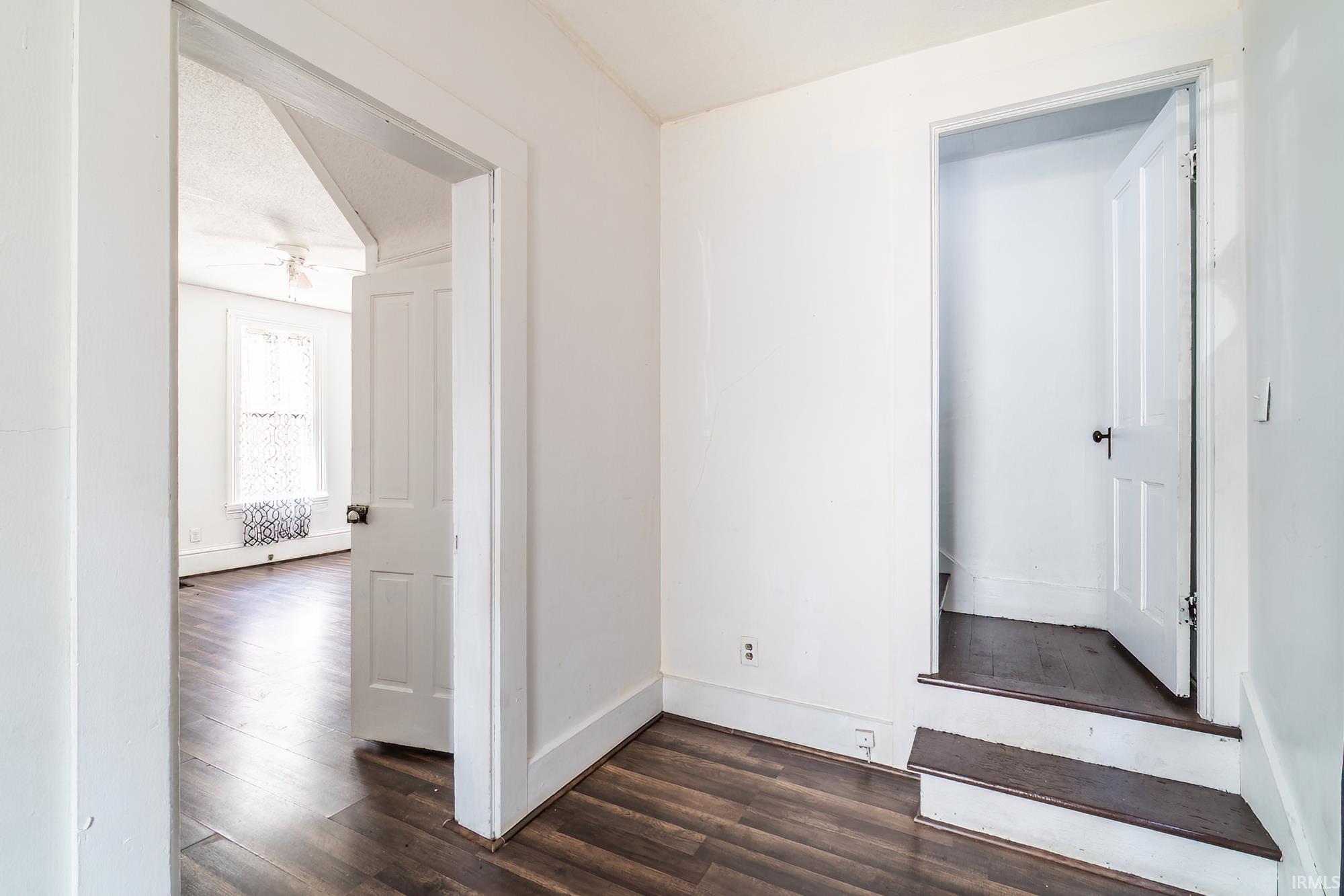 Hall with dark wood finished floors and baseboards