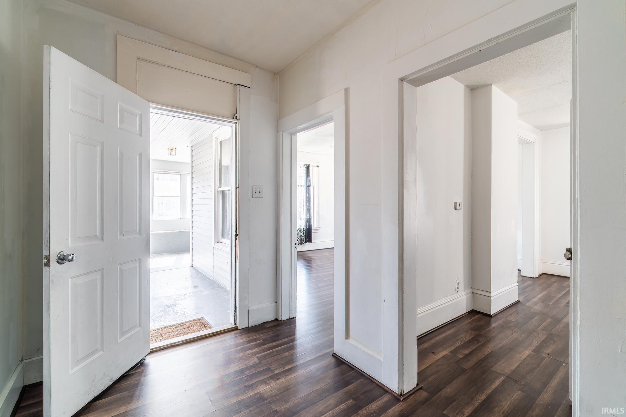 Hallway with dark wood-style flooring and baseboards