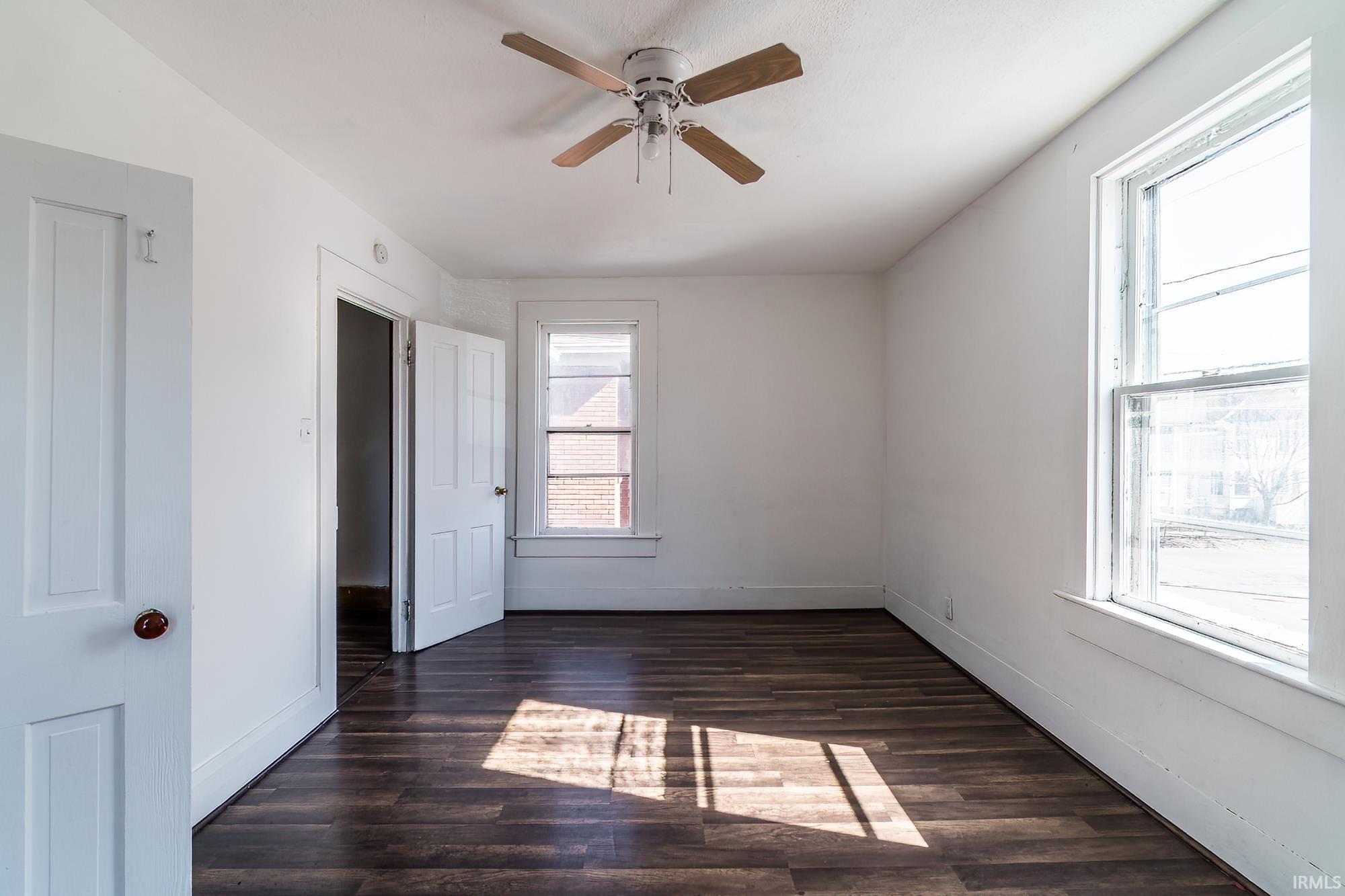 Unfurnished bedroom with dark wood-style flooring and ceiling fan