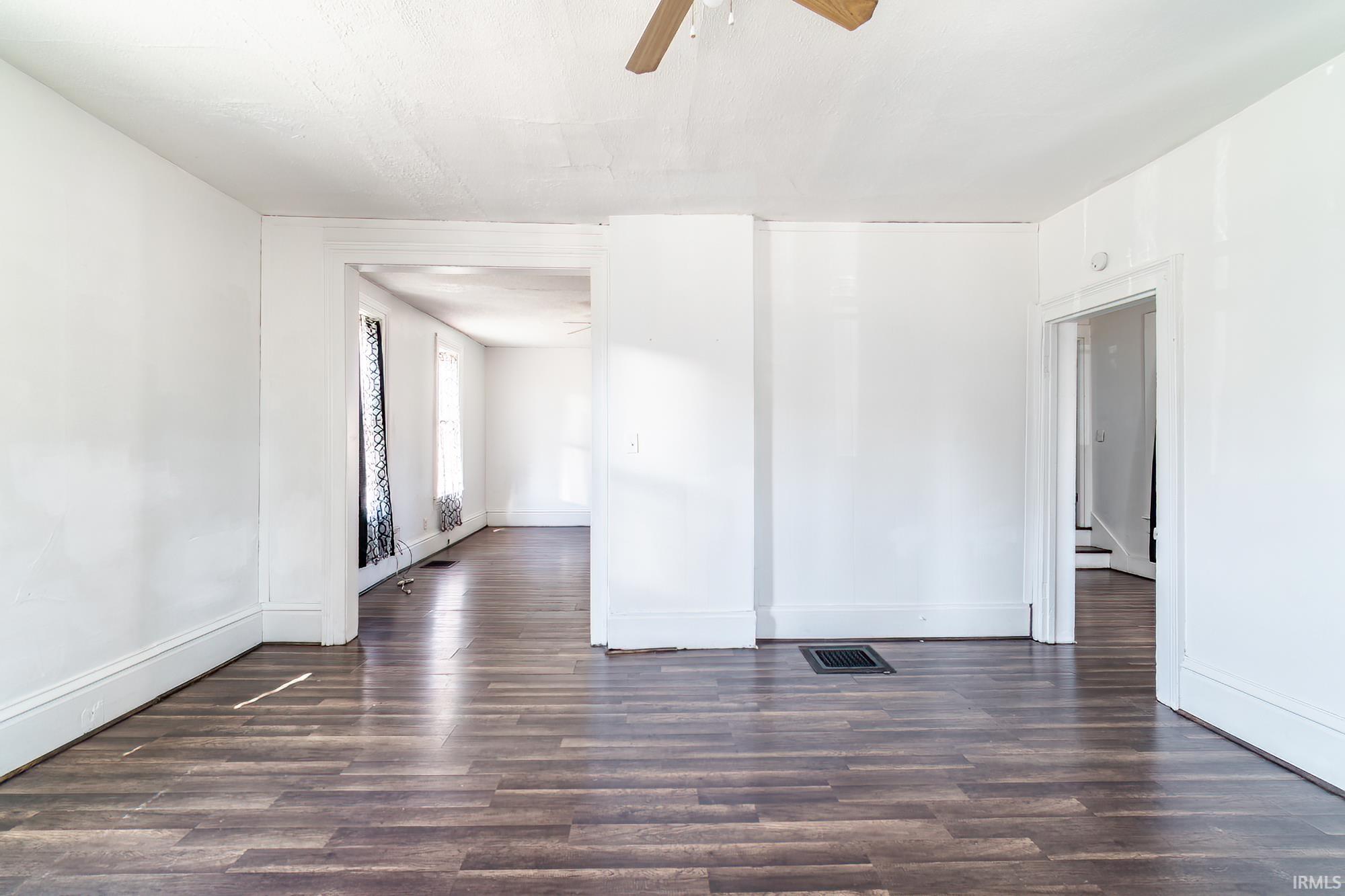 Spare room featuring ceiling fan and dark wood-type flooring