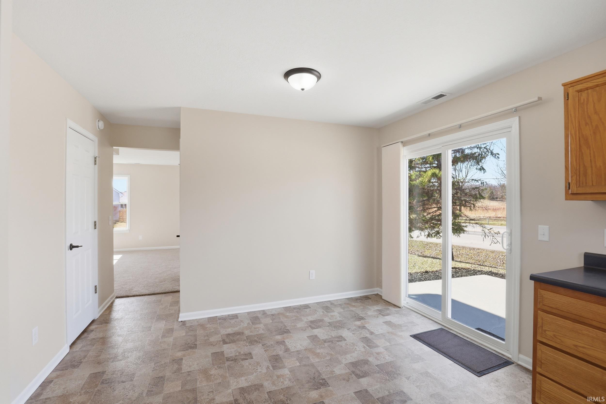 Unfurnished dining area featuring baseboards and stone finish flooring