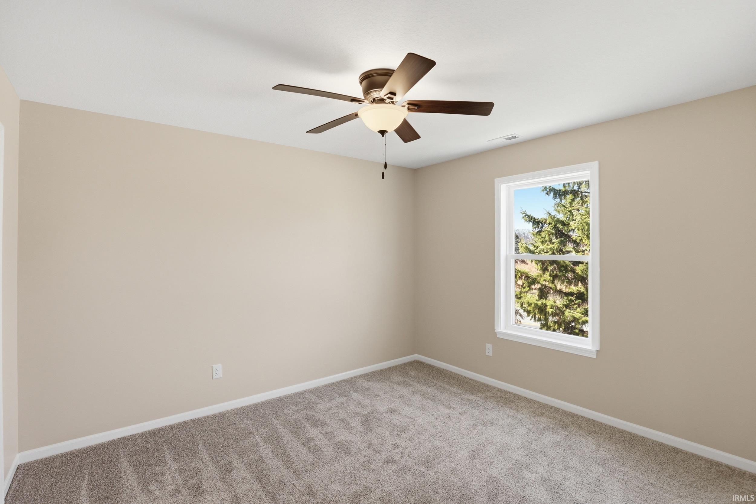 Spare room with light carpet and ceiling fan