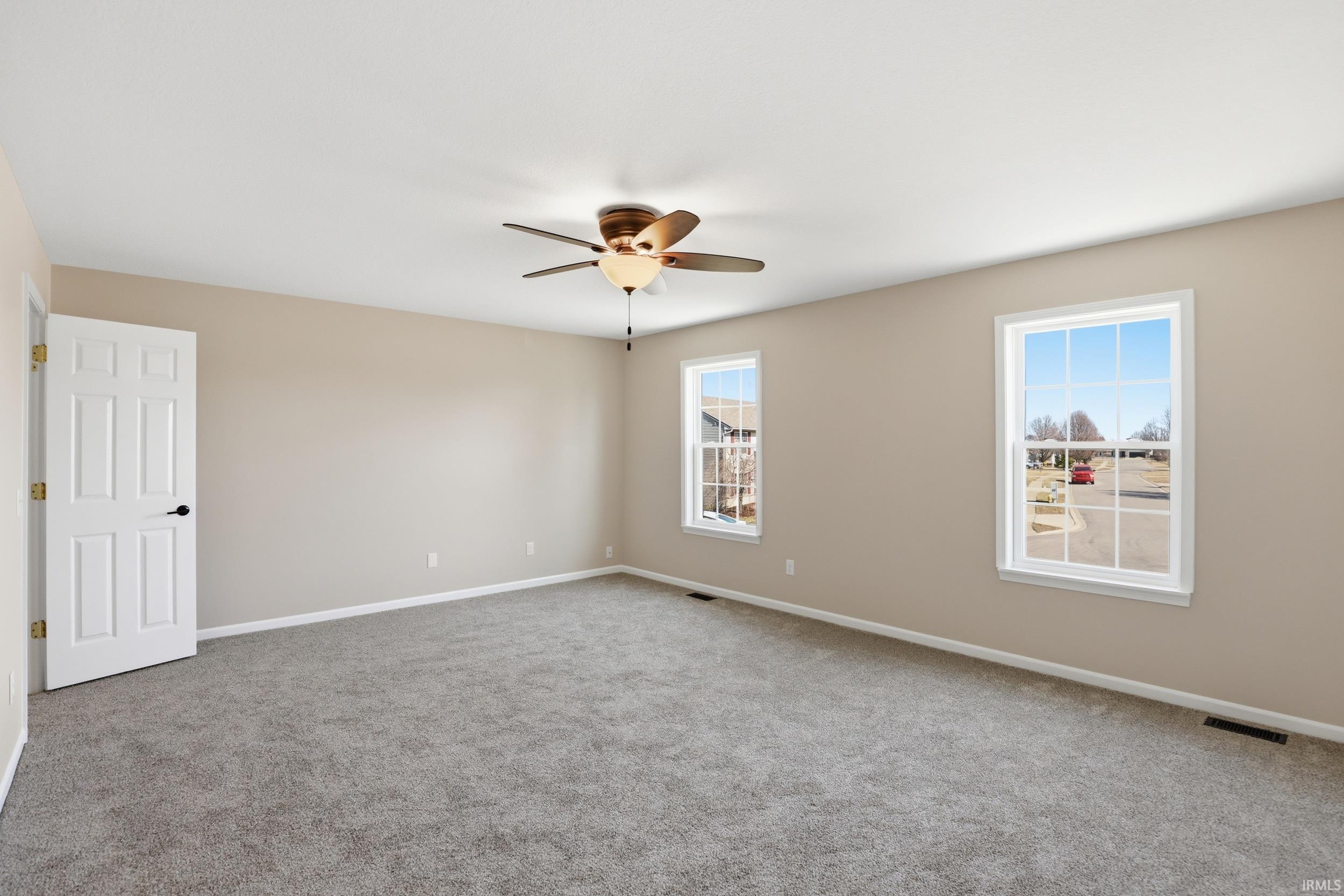 Carpeted spare room with baseboards and a ceiling fan