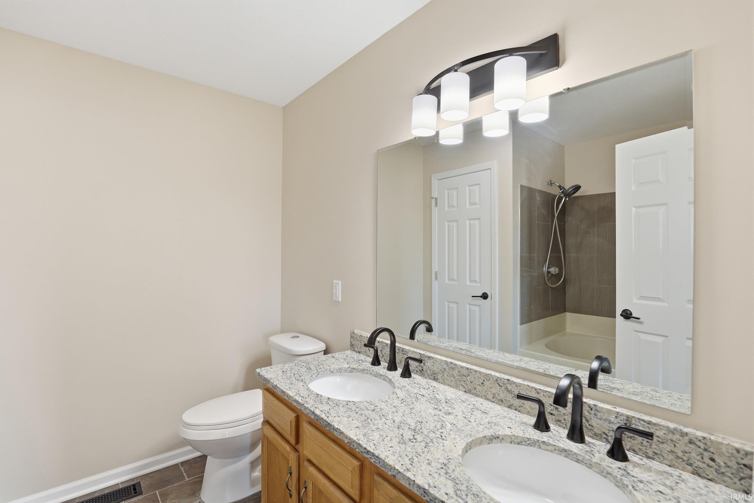 Bathroom featuring double vanity and shower / bath combination