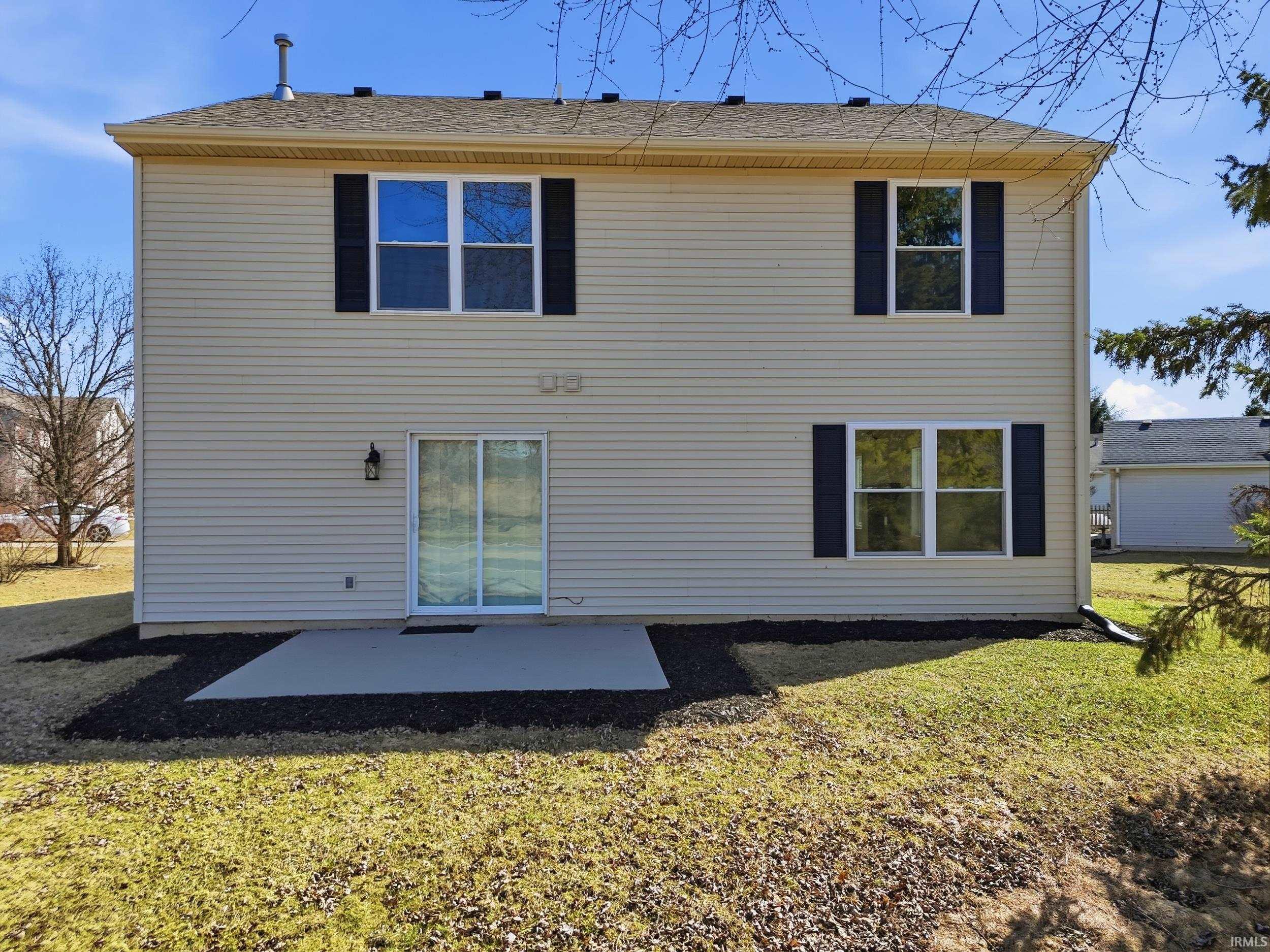 Rear view of property featuring a patio and a lawn
