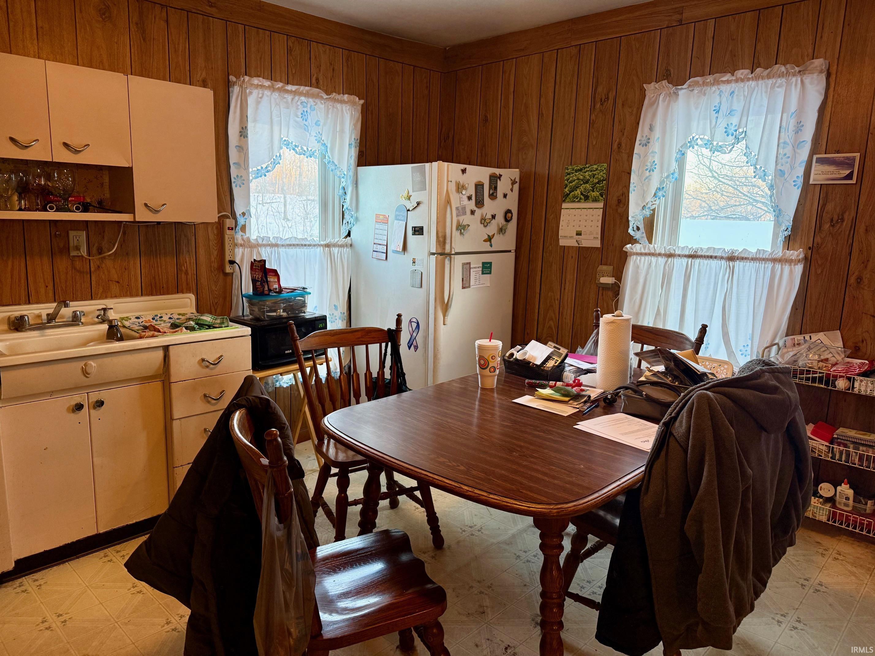 Dining area with wood walls and light floors