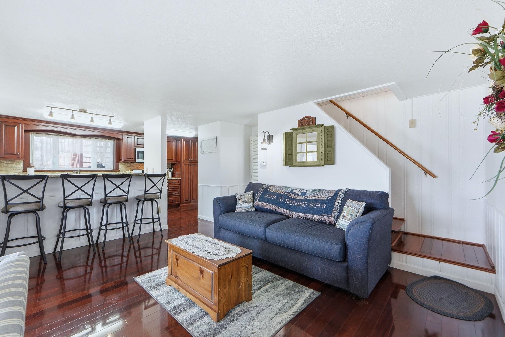 Living area featuring dark wood-style floors and stairway
