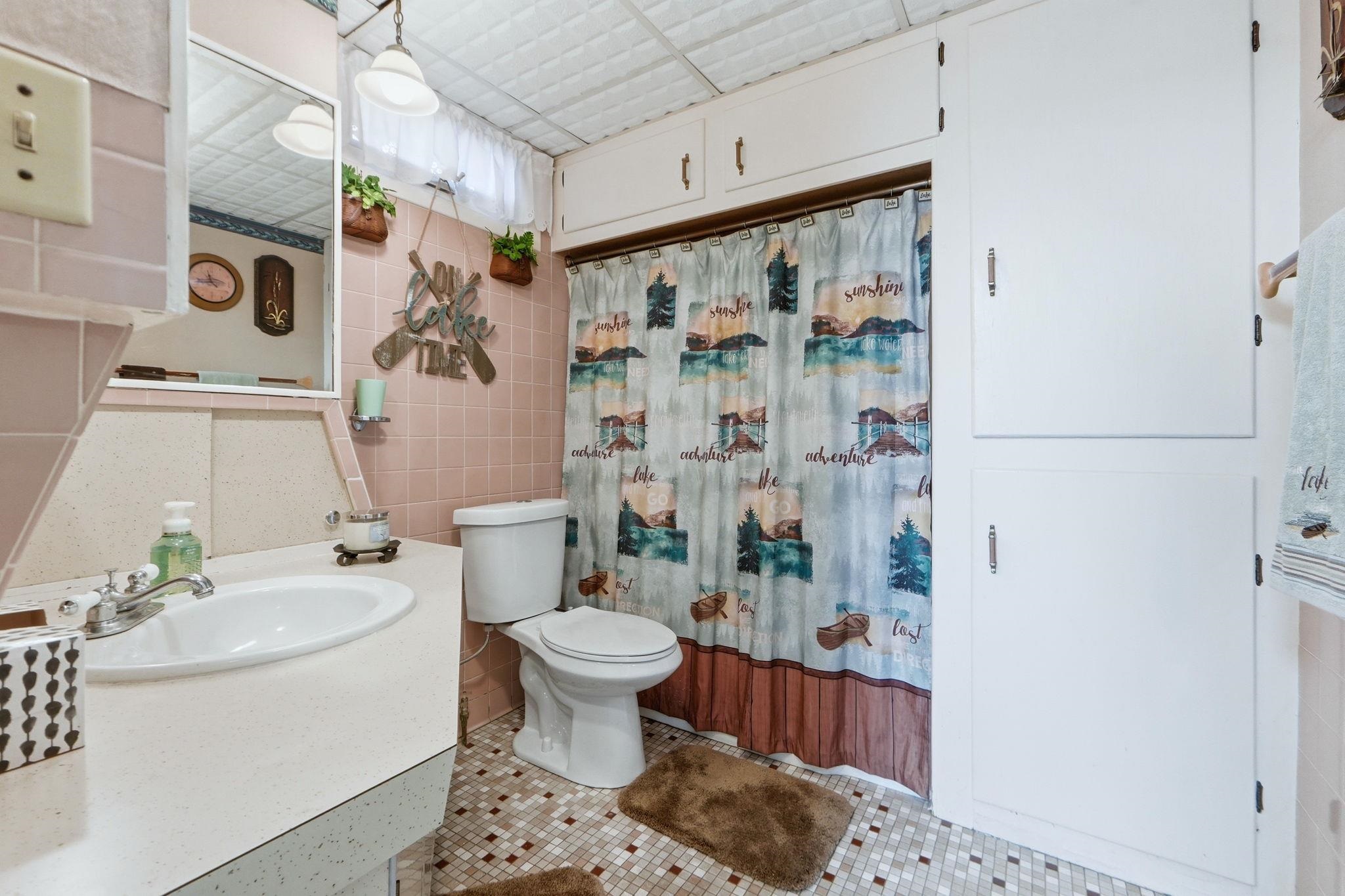 Full bathroom featuring vanity, tile walls, and light tile patterned flooring