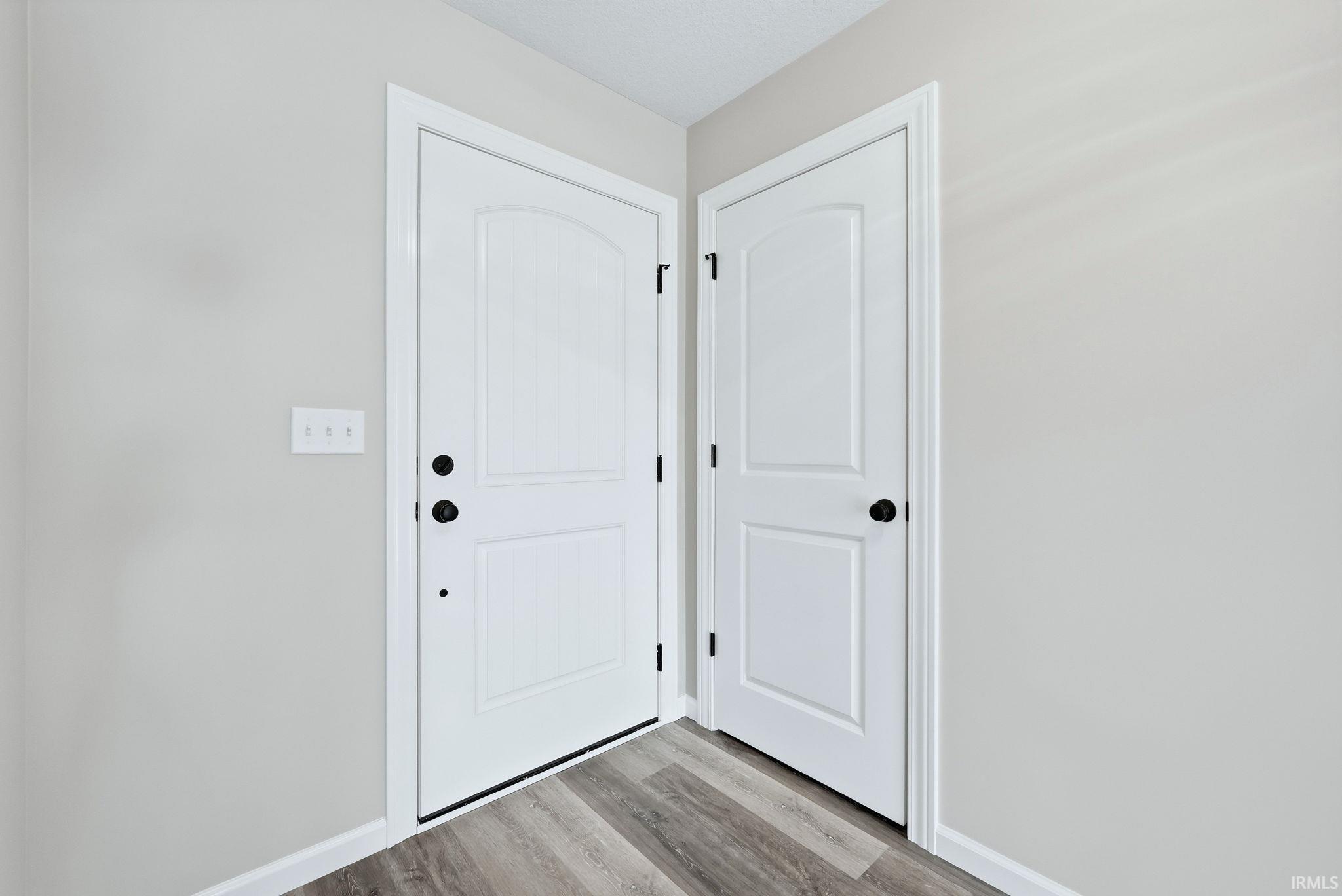 Doorway with baseboards and wood finished floors