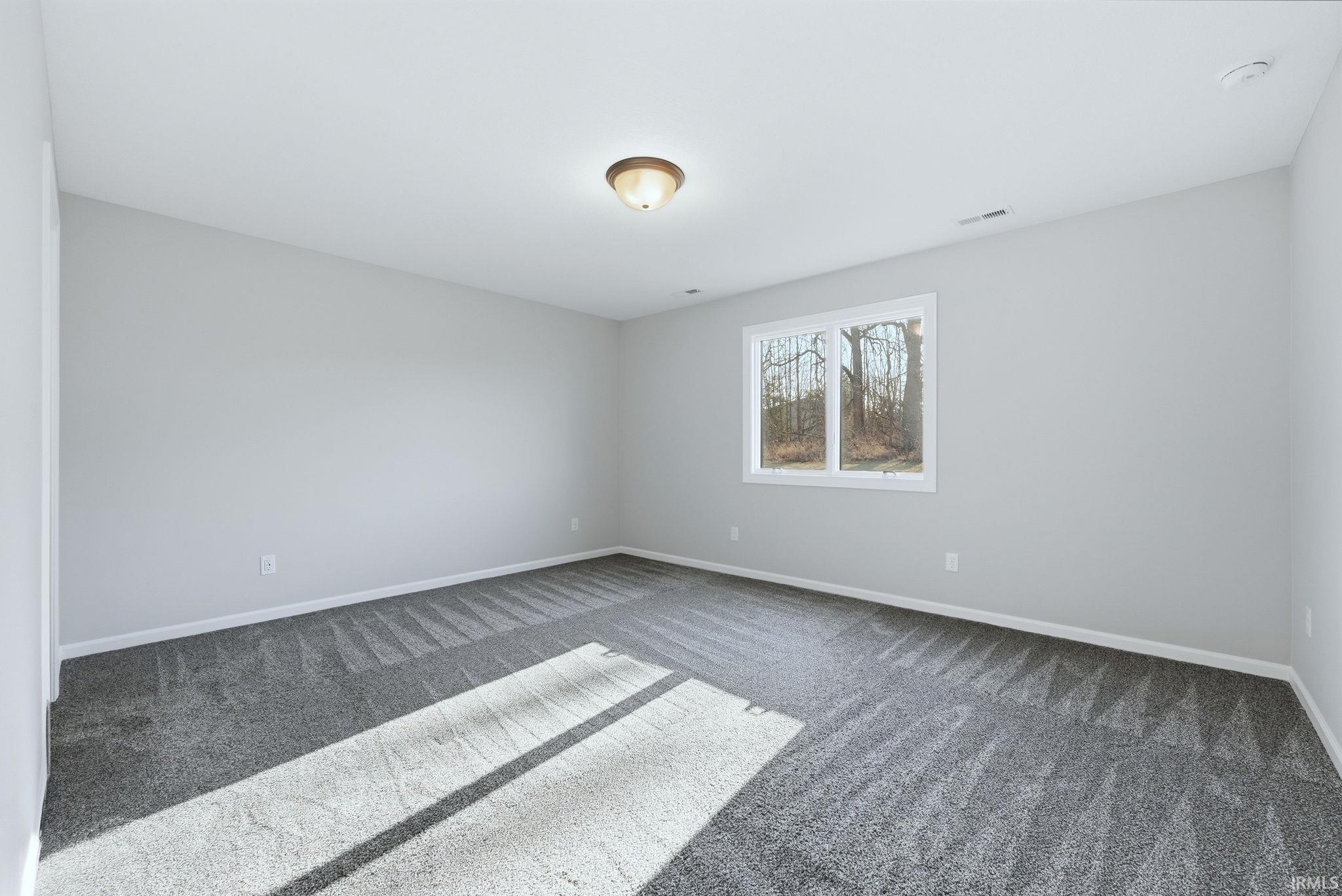 Unfurnished room with dark carpet