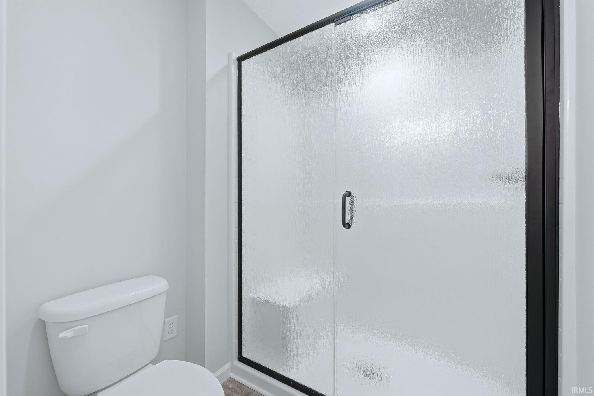 Bathroom featuring a stall shower and toilet