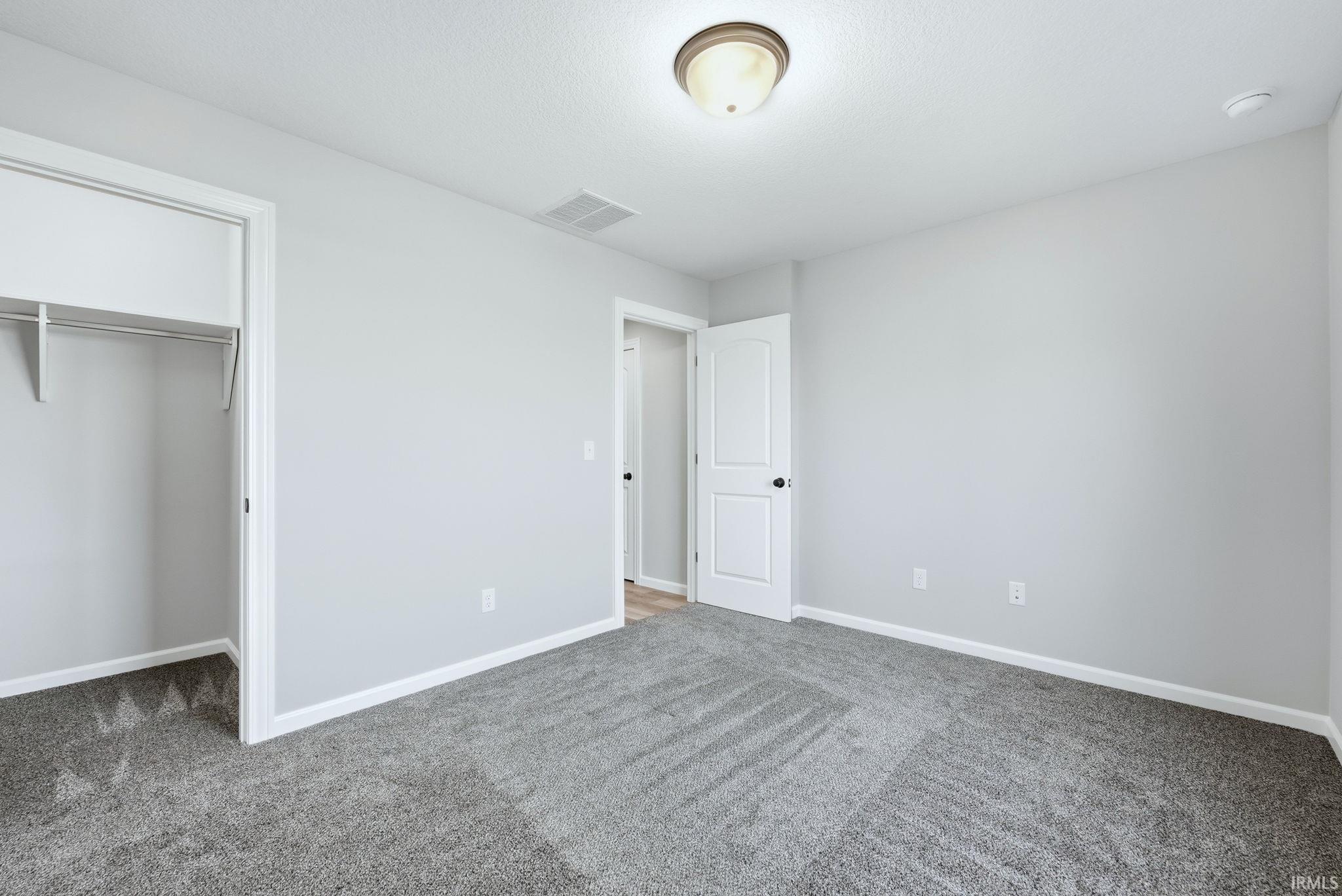 Unfurnished bedroom featuring carpet and a closet