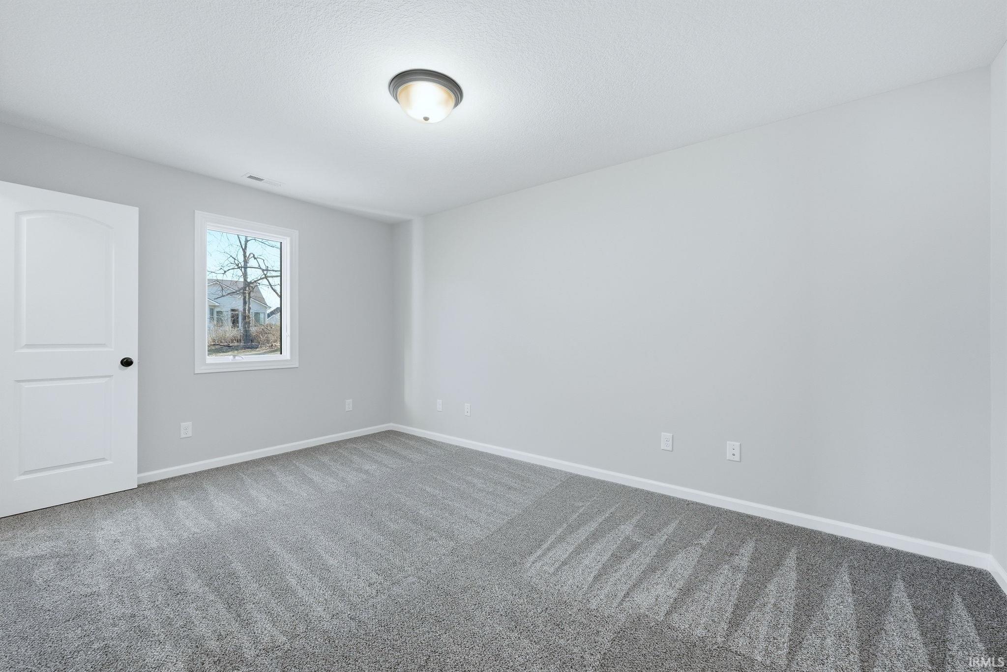 Empty room featuring baseboards and light colored carpet
