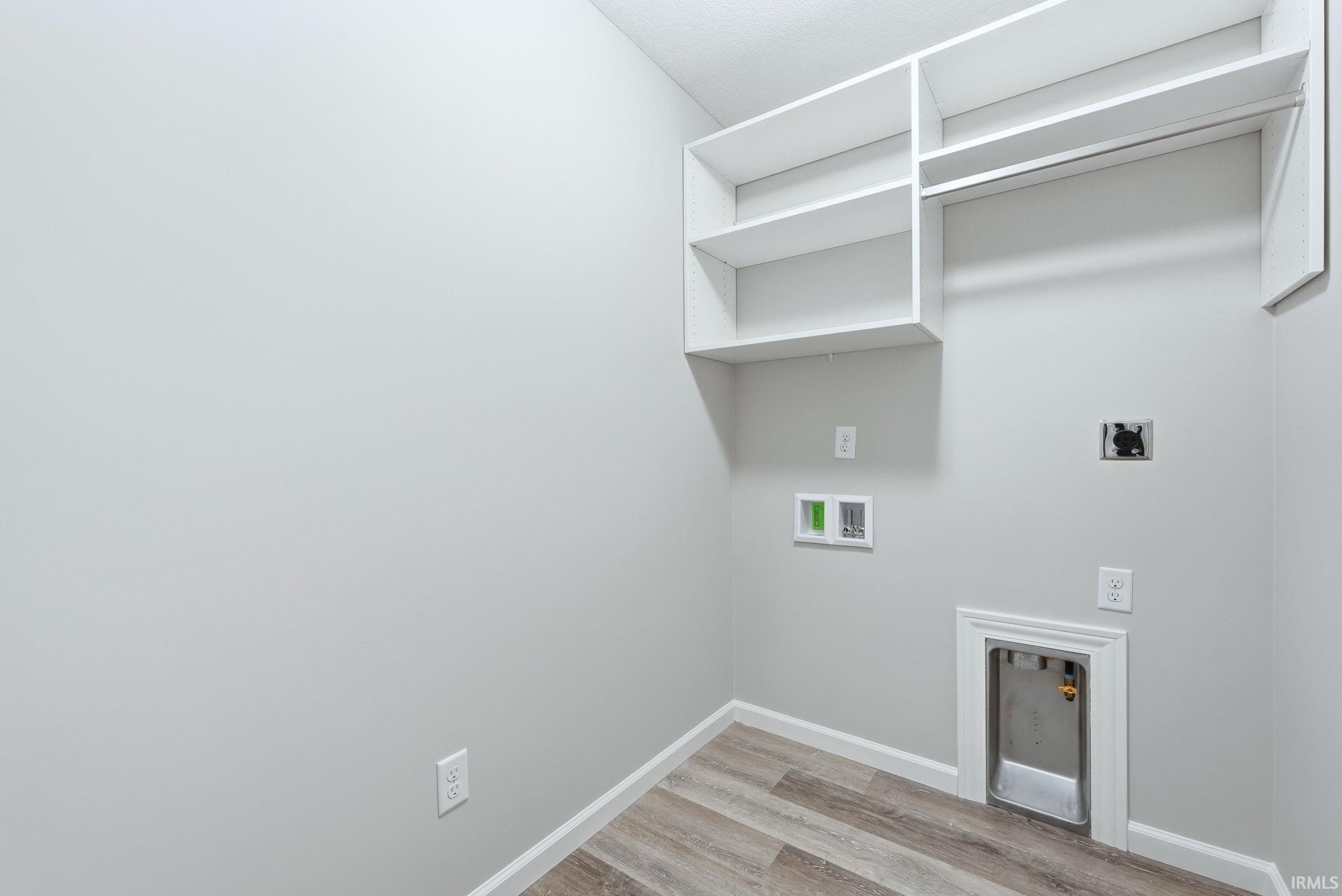 Laundry room with light wood-style floors, hookup for a washing machine, and electric dryer hookup