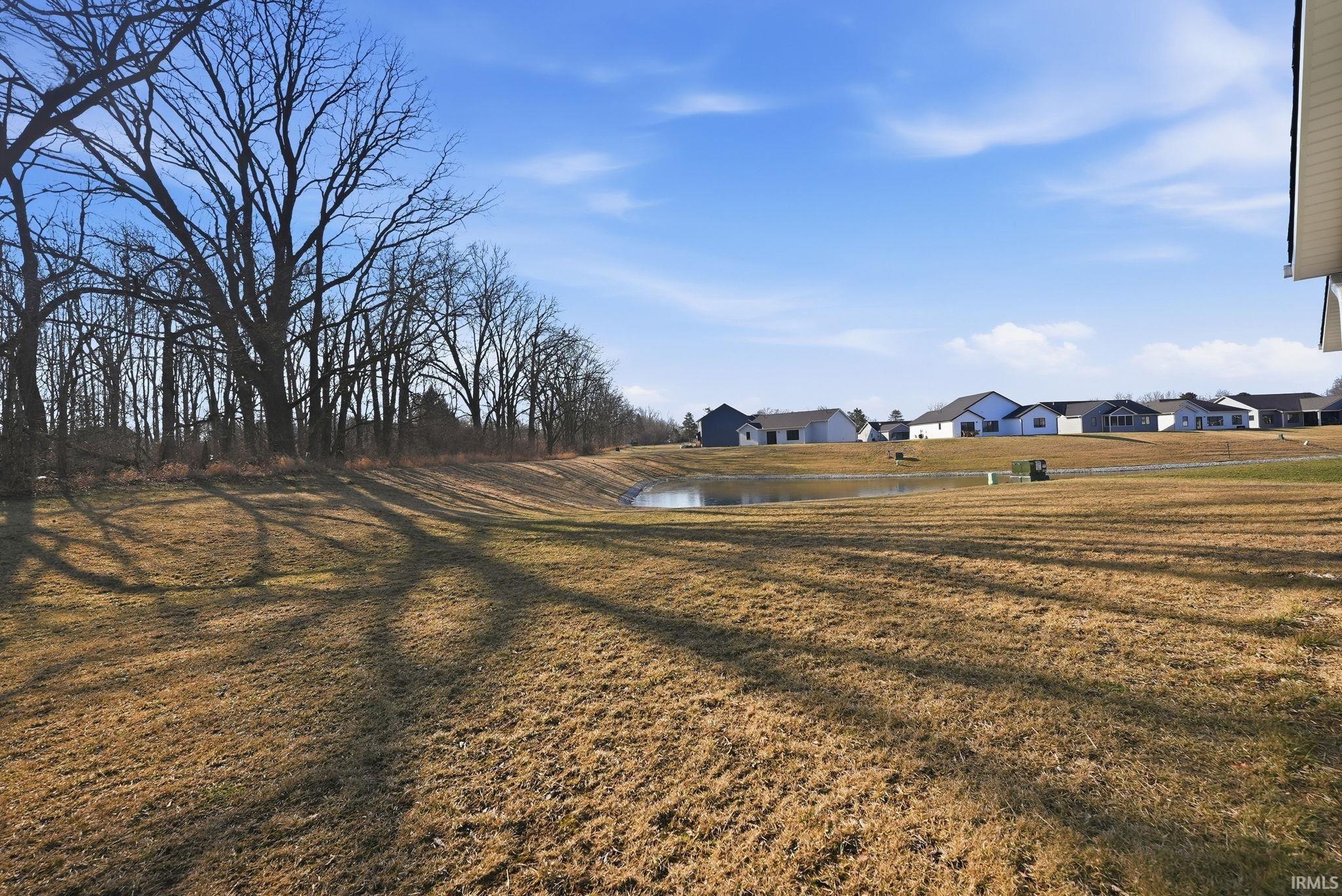 View of grassy yard featuring a water view and a residential view