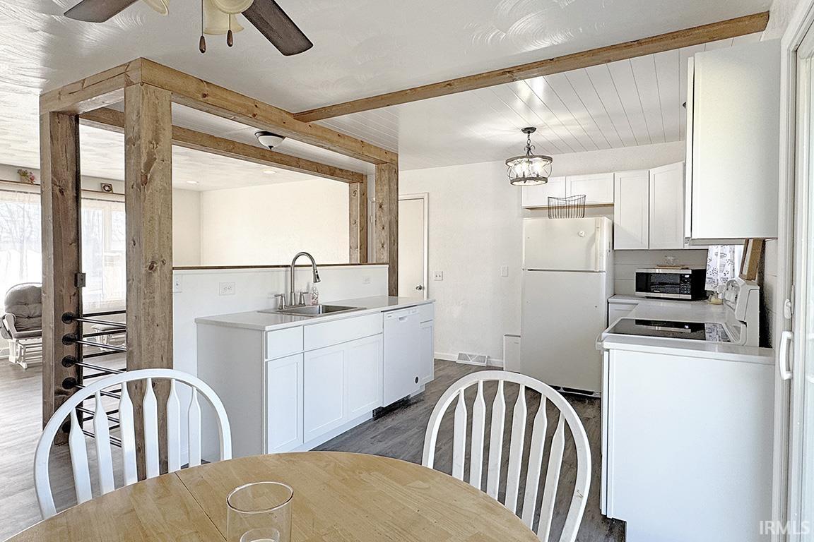 Kitchen featuring white cabinetry, white appliances, light countertops, ceiling fan, and beam ceiling