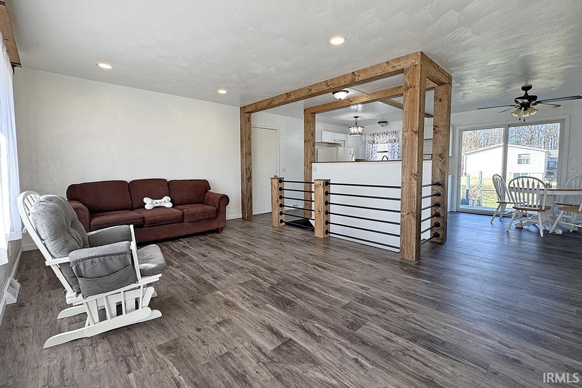 Living area with dark wood-style flooring, ceiling fan, and recessed lighting