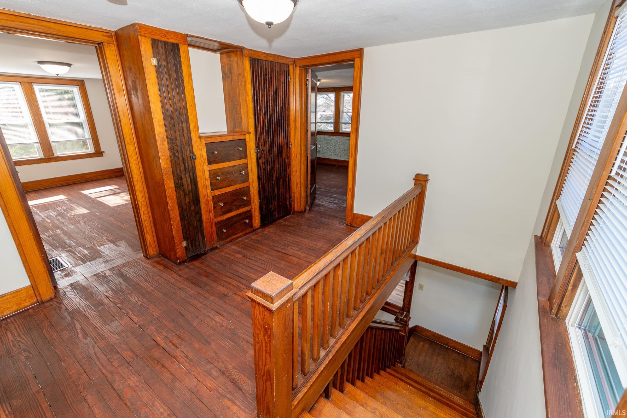 Stairway with hardwood / wood-style flooring and baseboards