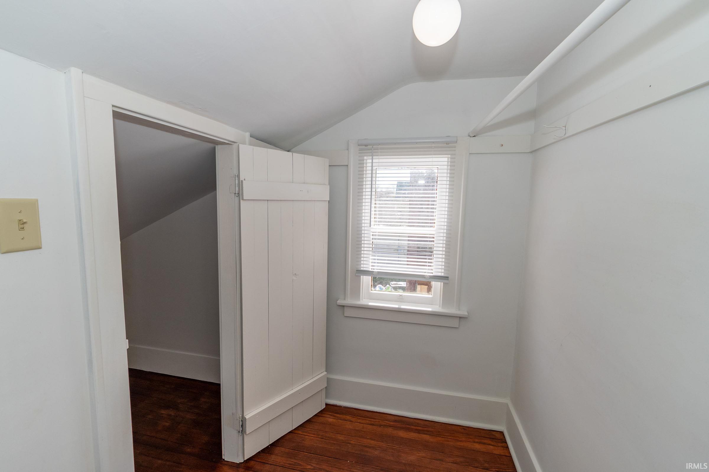 Walk in closet featuring dark wood-style floors and vaulted ceiling