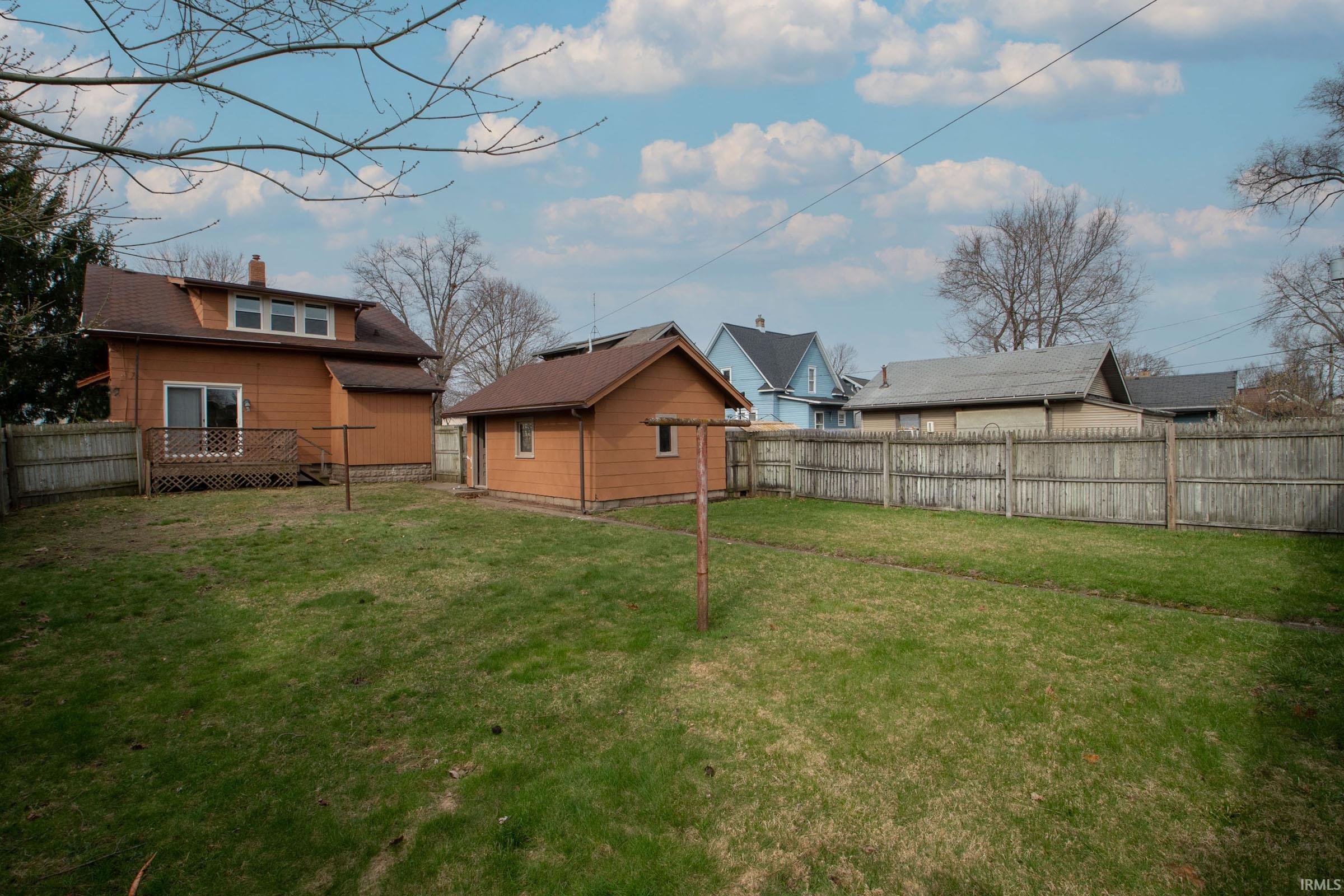 Fenced backyard featuring a wooden deck