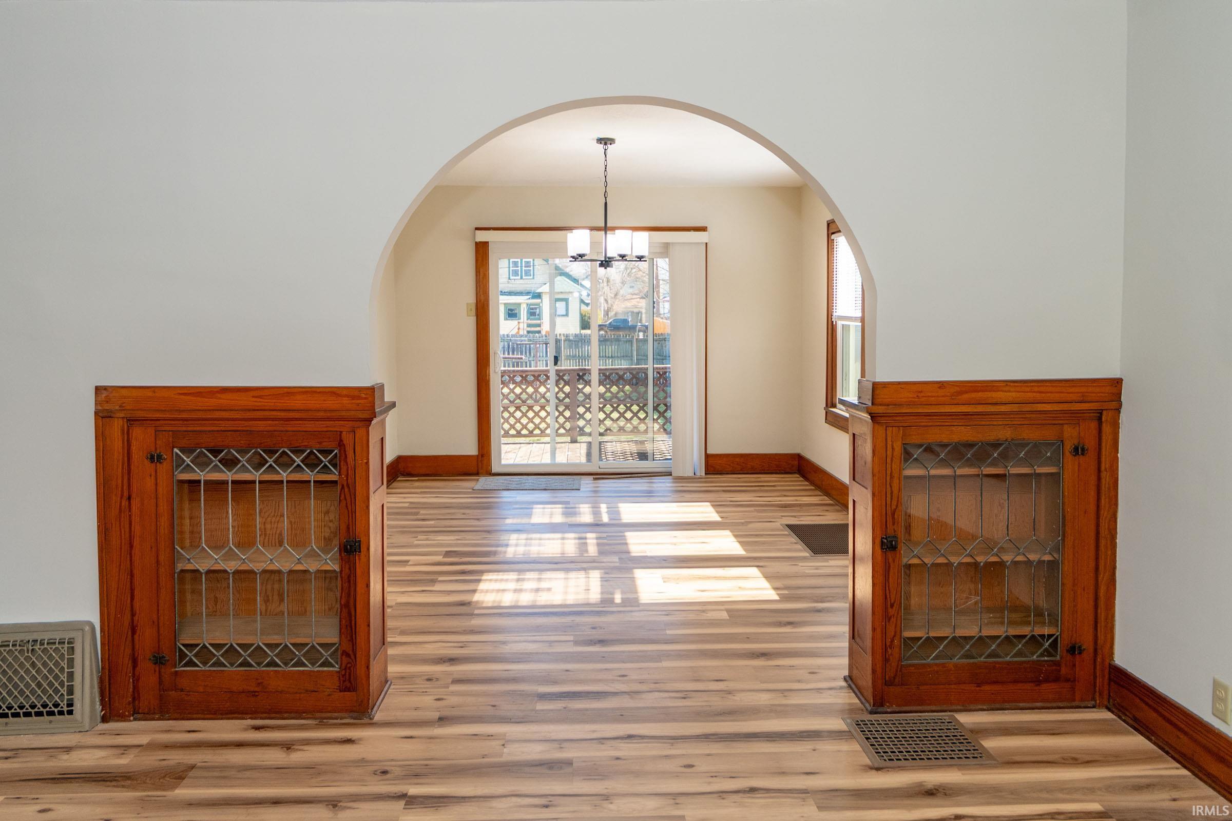 Foyer entrance with light wood-type flooring and suspended lighting