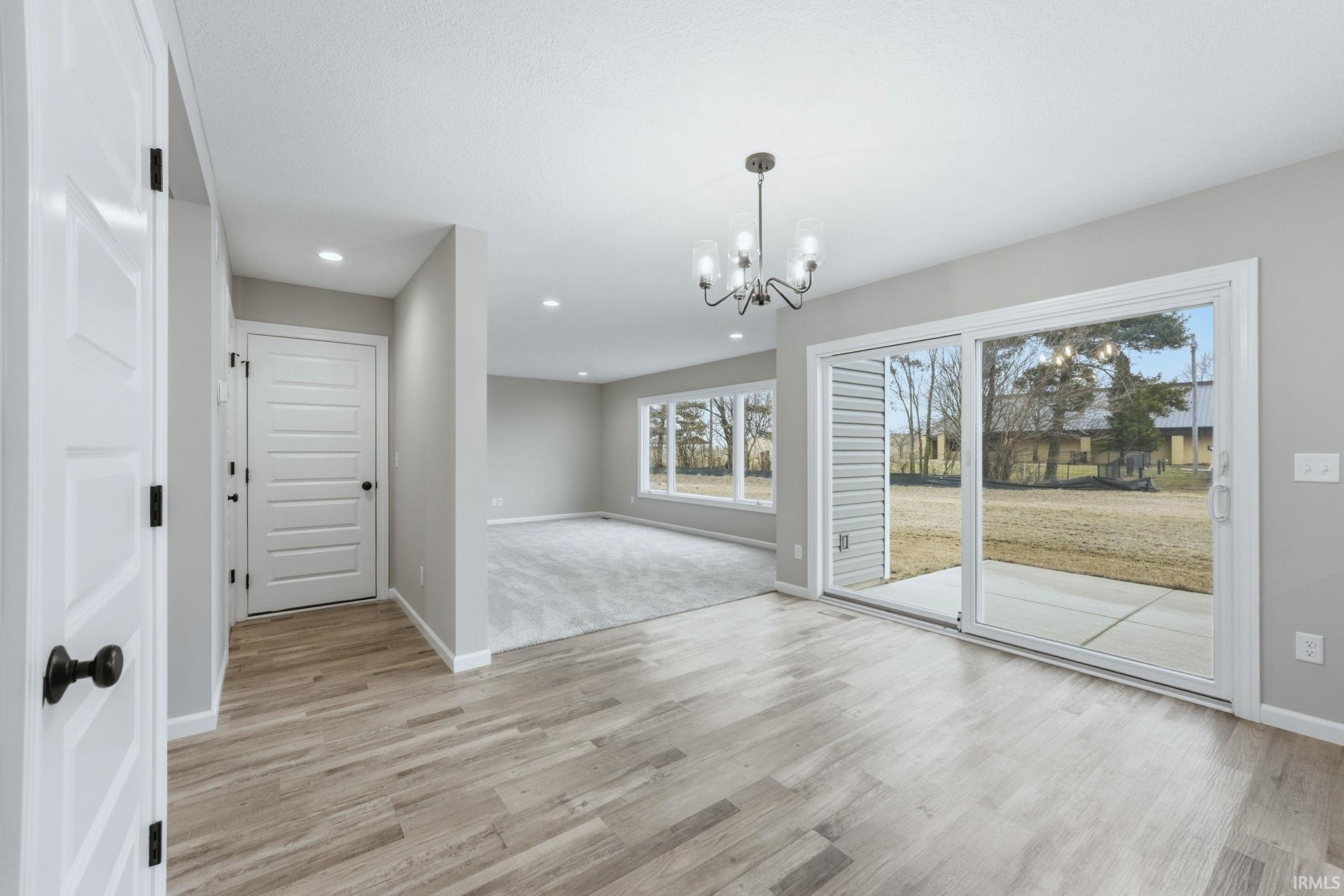 Unfurnished dining area featuring suspended lighting and light wood-style flooring