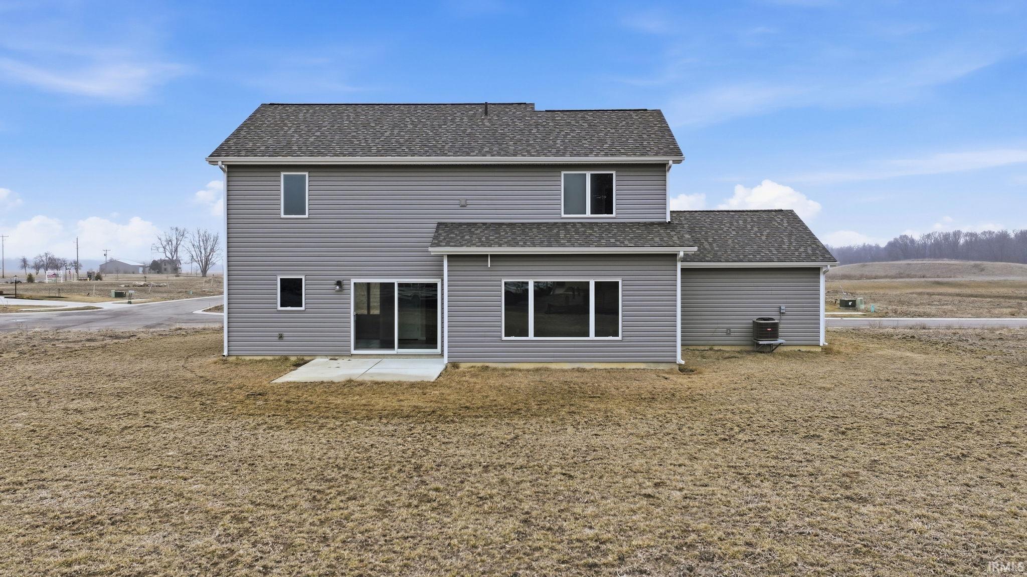 Back of house with a patio area and roof with shingles
