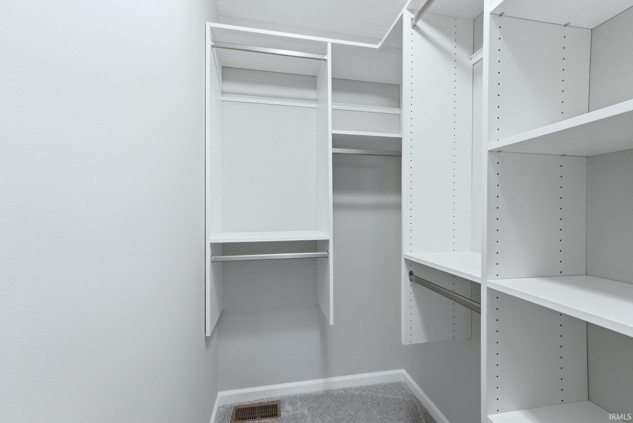 Walk in closet featuring light colored carpet