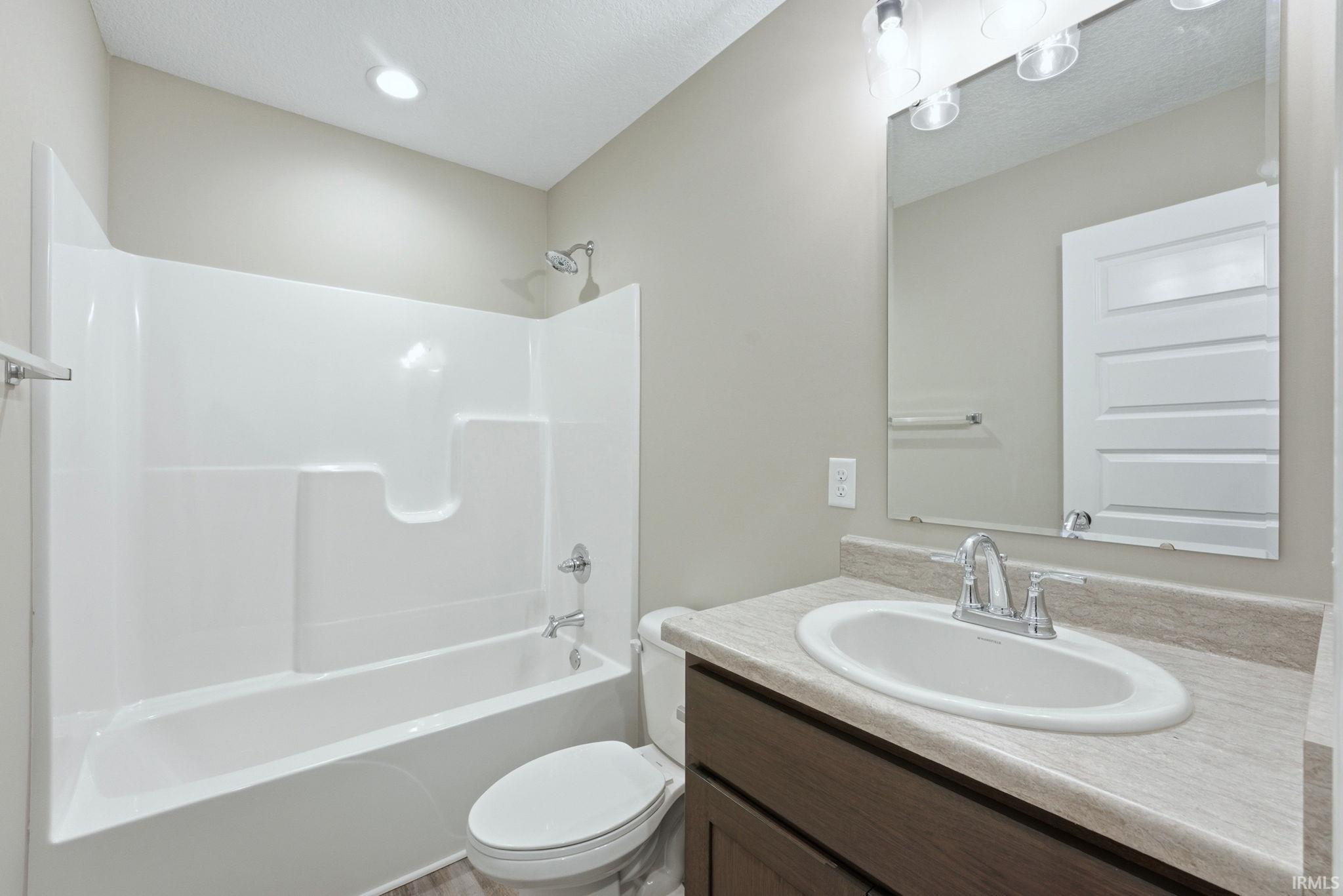 Bathroom featuring vanity and washtub / shower combination